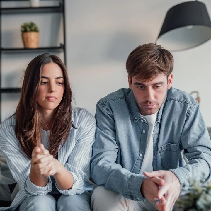 Couple sitting quietly before discussing relationship concerns in therapy.