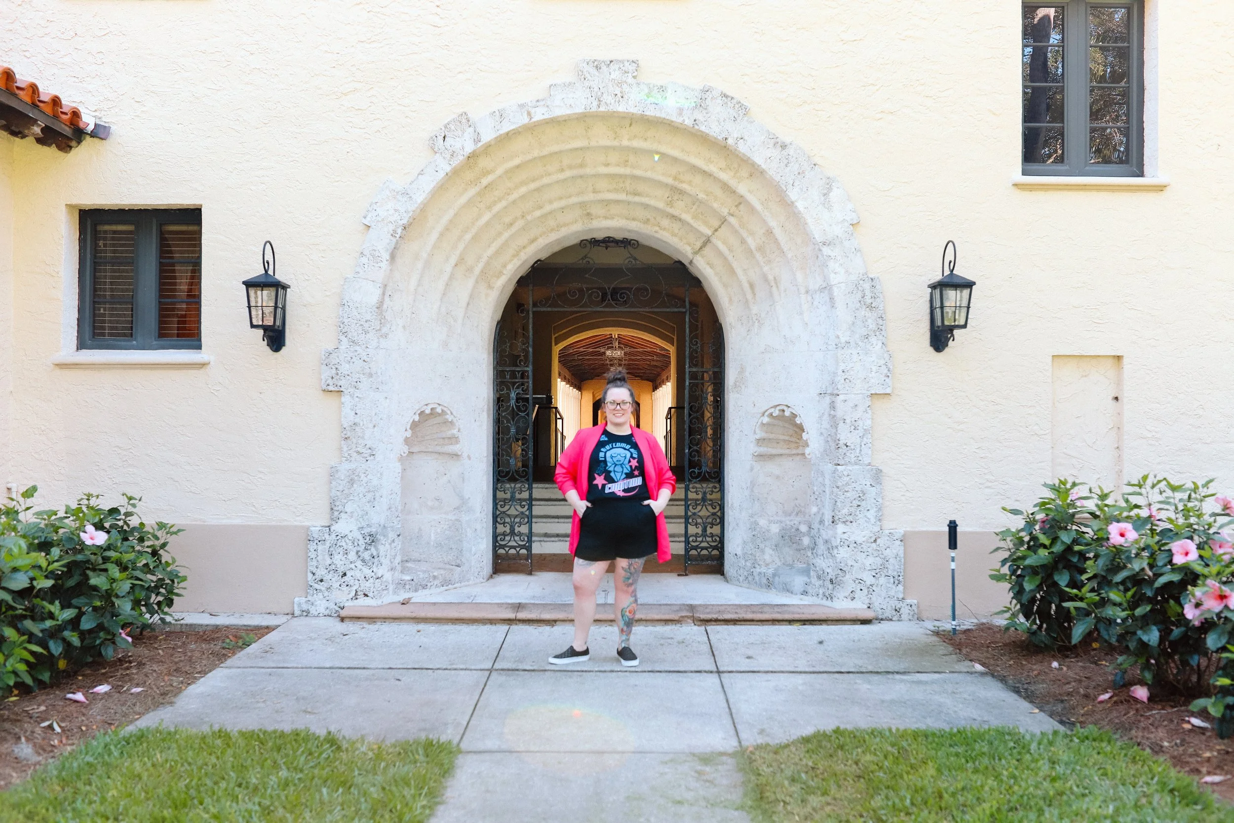 Therapist Mariah Plociniak standing outdoors in front of an archway smiling.