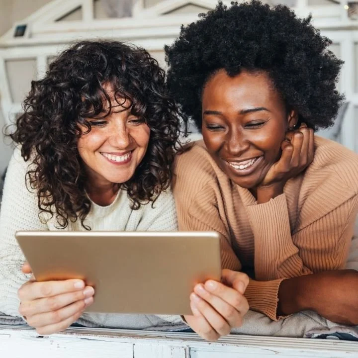 Couple smiling together while participating in an online relationship counseling session.
