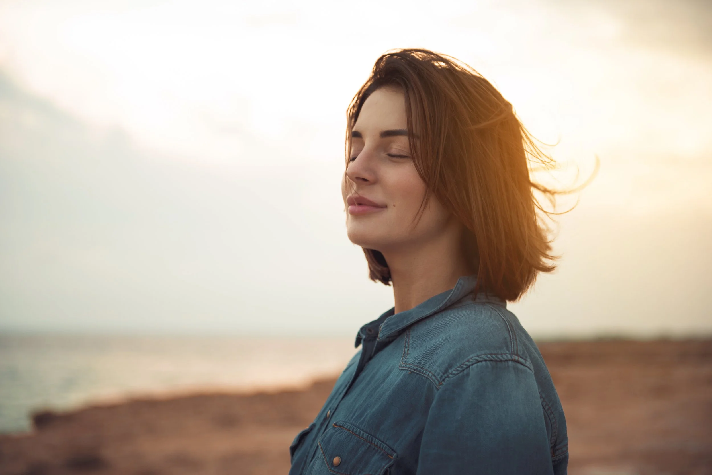 Woman standing quietly in nature, pausing to reflect during a self-discovery journey in therapy in Florida.