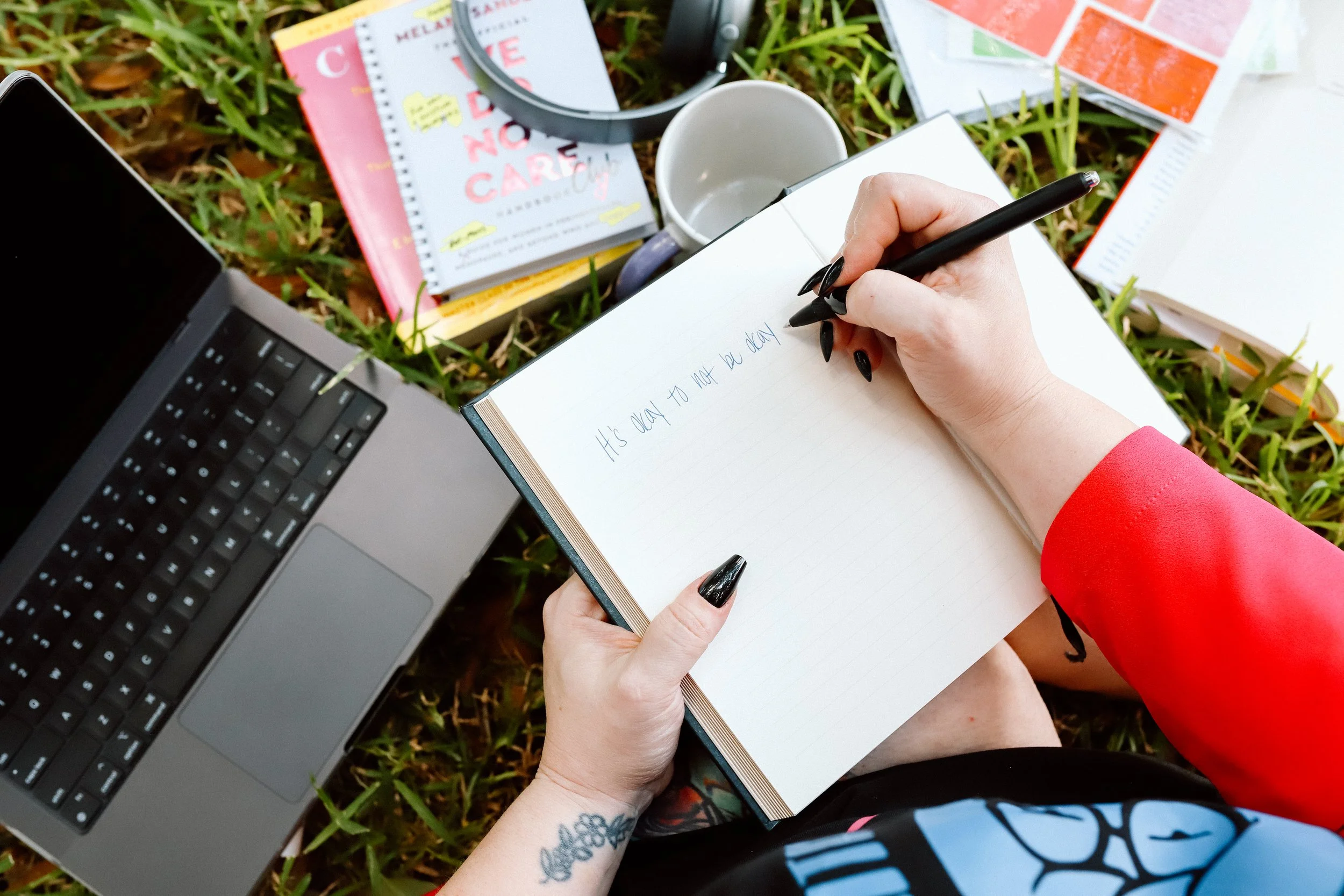 Women's therapist Dr. Mariah Plociniak writing in a journal outdoors in Orlando, Florida, specializing in perimenopause, ADHD, burnout, and anxiety.