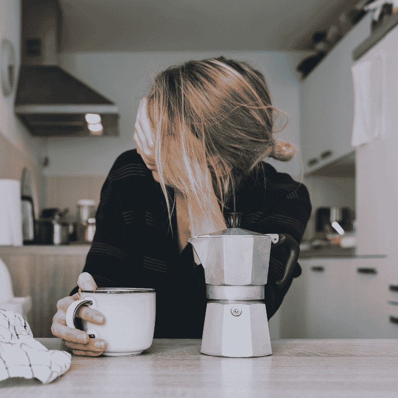 Exhausted woman leaning on kitchen counter