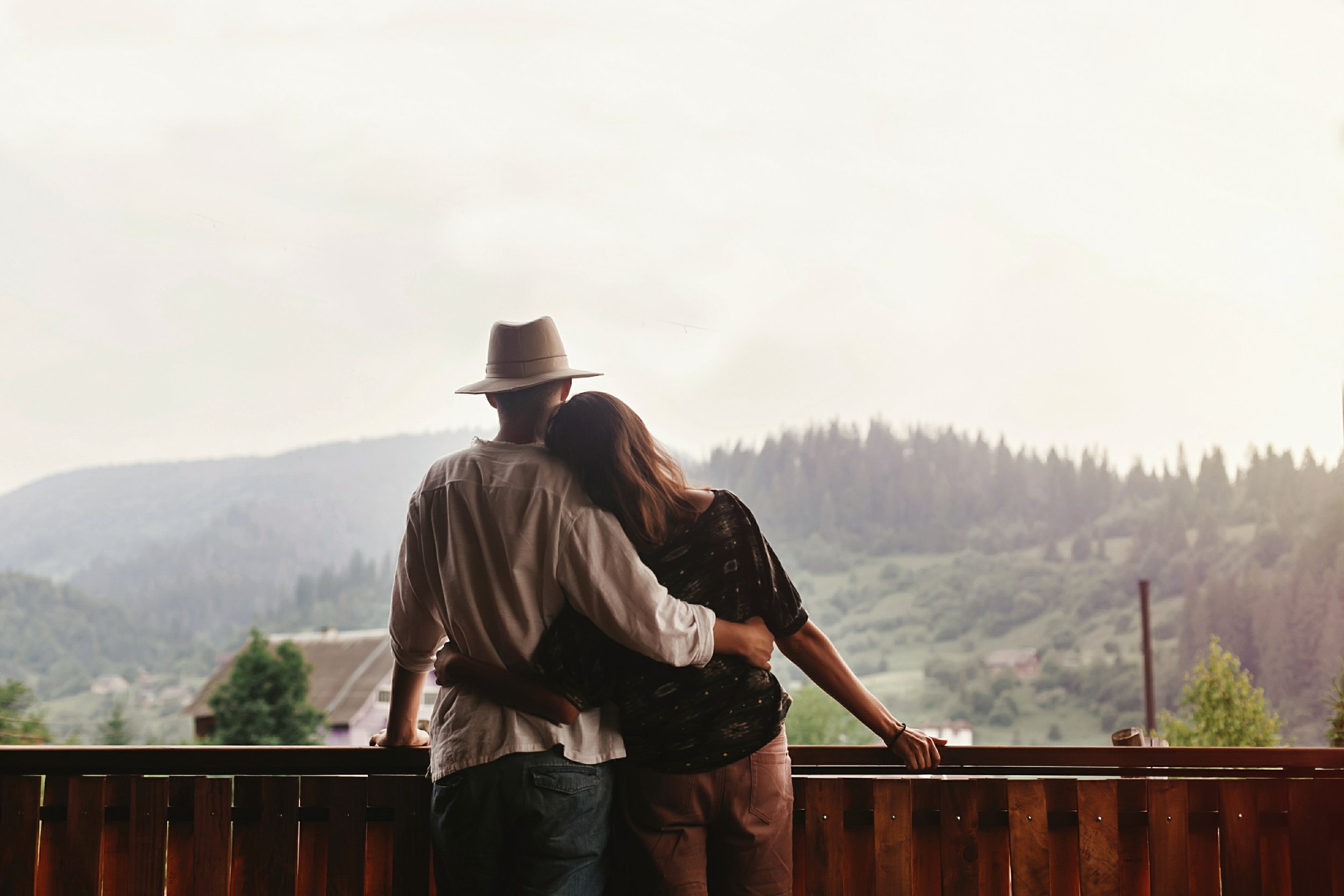 Couple embracing on a balcony overlooking the Central Florida landscape, symbolizing emotional healing and connection through couples therapy at Sacred Healing Counseling