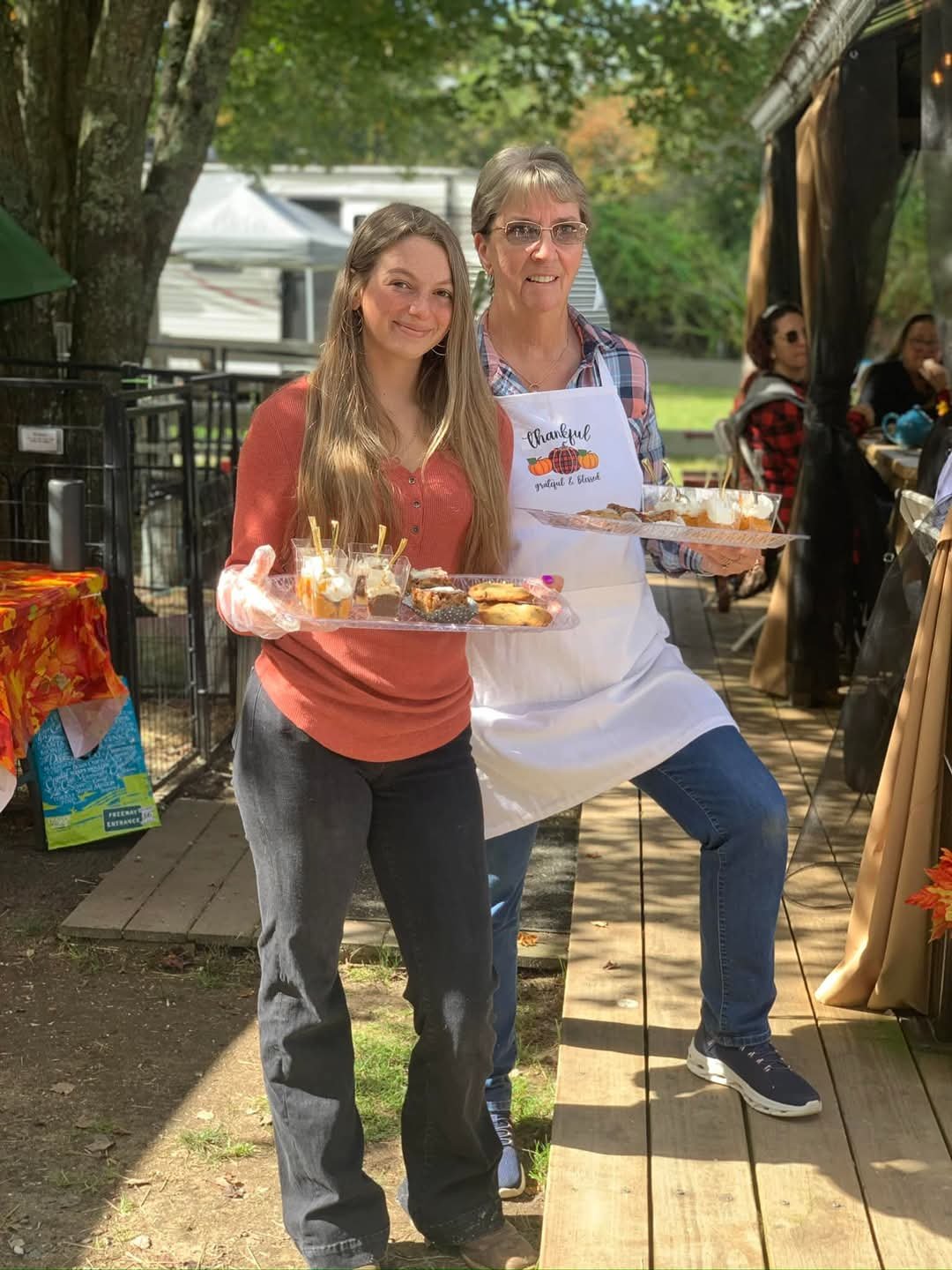 Volunteers Becky and Kaitlyn serving goodies to the guests.