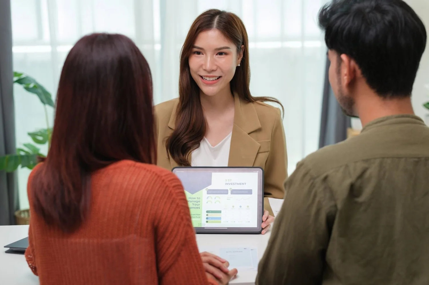 An insurance adviser talking a couple through their options on a tablet