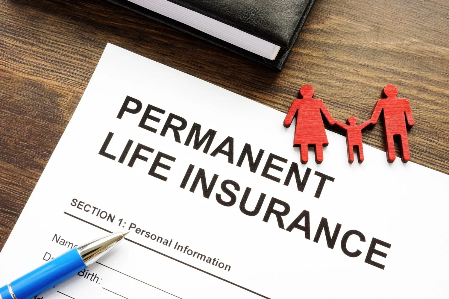 A life insurance application form with a pen and small red figures of a family