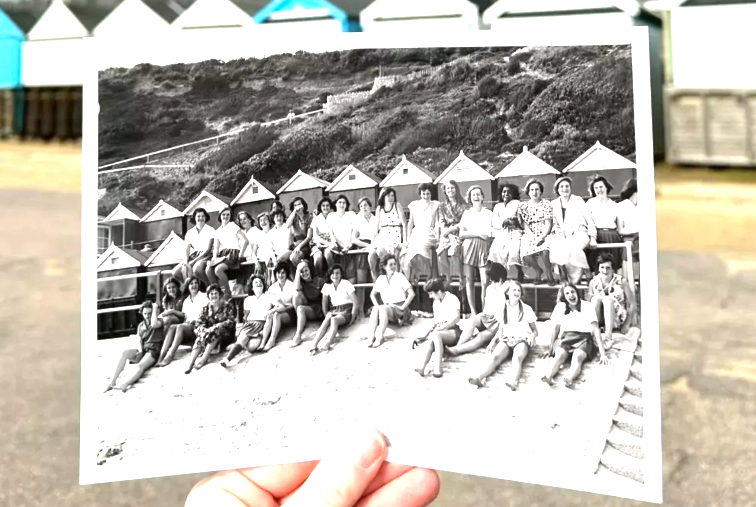 An archive photo held with a hand in the same location the original photo was taken