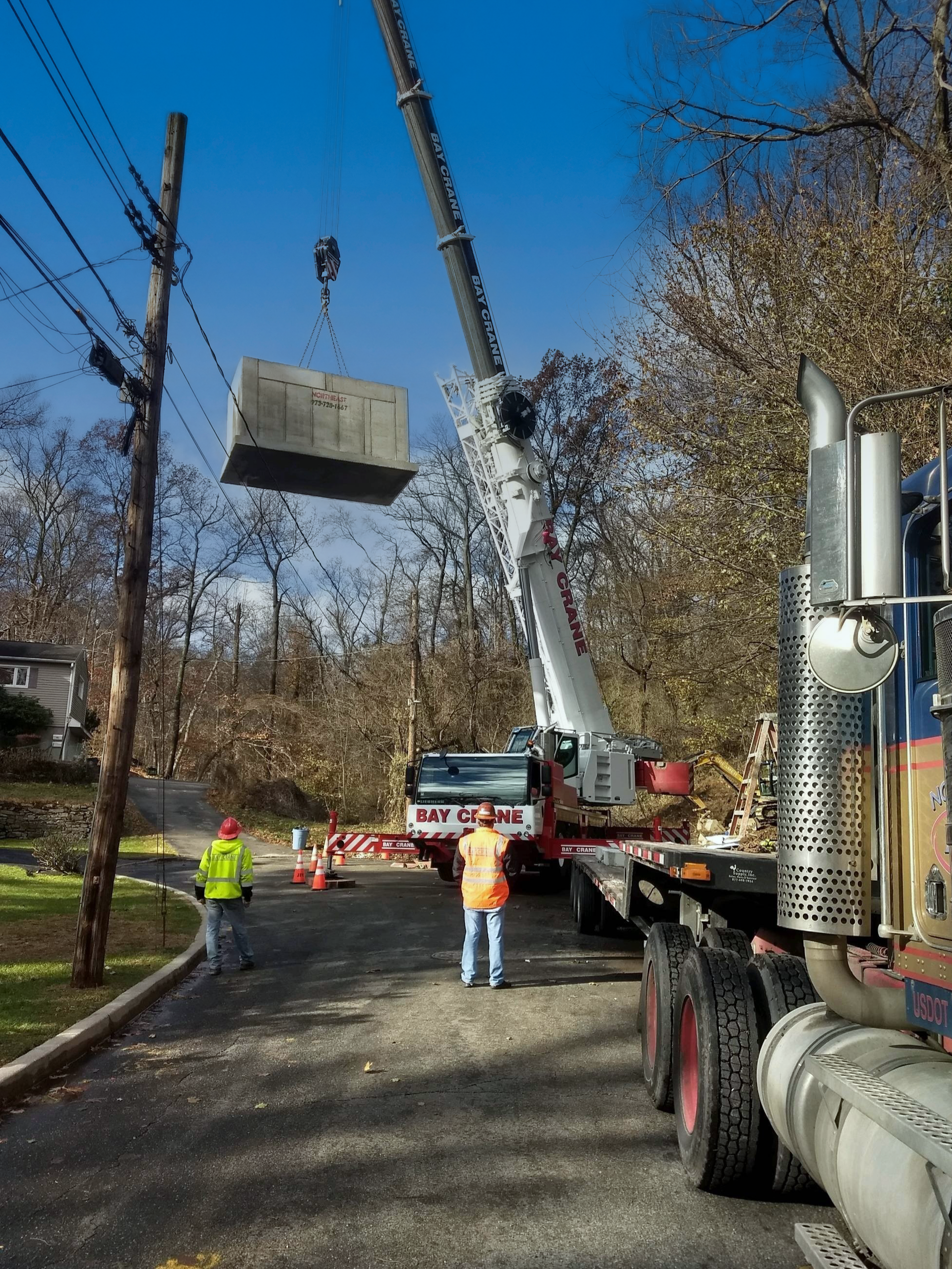 Precast concrete structure being set in place by our boom truck at a jobsite