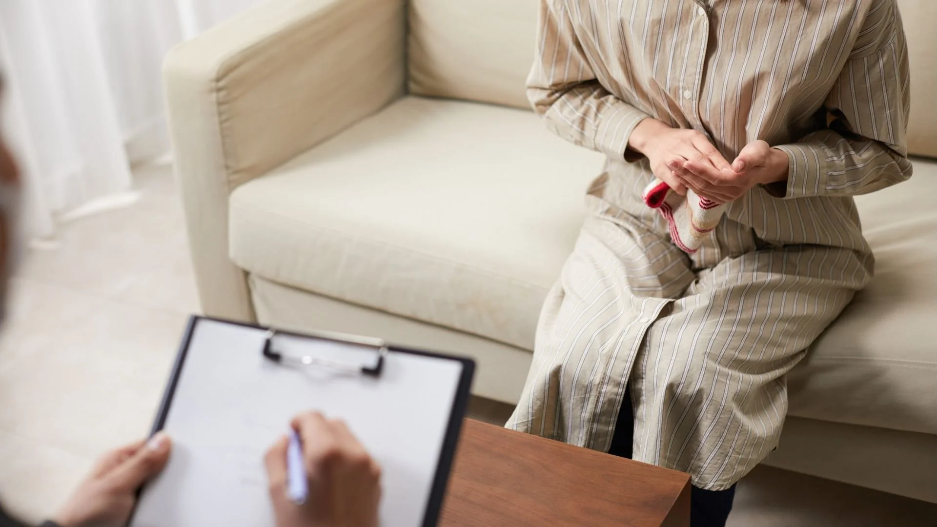A patient in casual attire discussing their feelings with a therapist during a session, addressing mental health concerns that may include various types of anxiety.