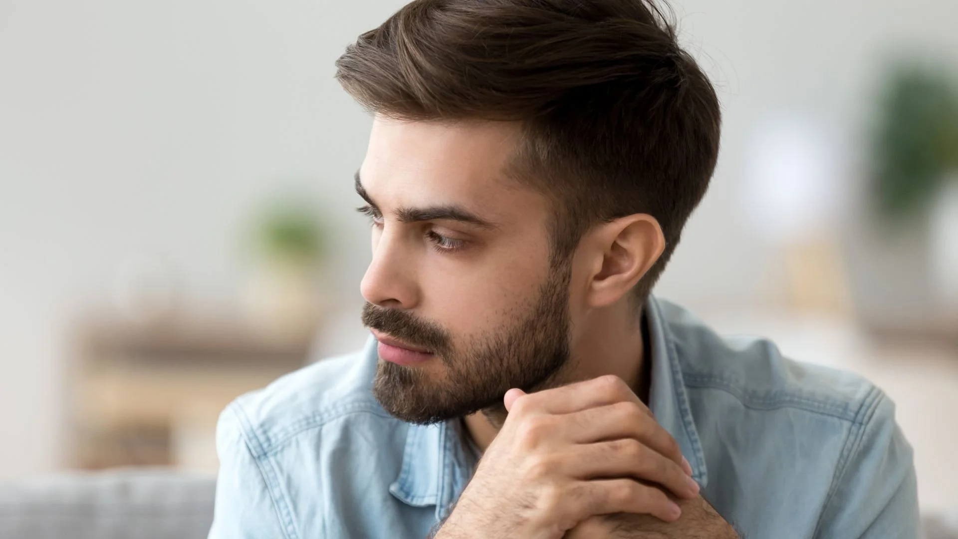 Thoughtful concerned man lost in intrusive thoughts while trying to find a problem solution.