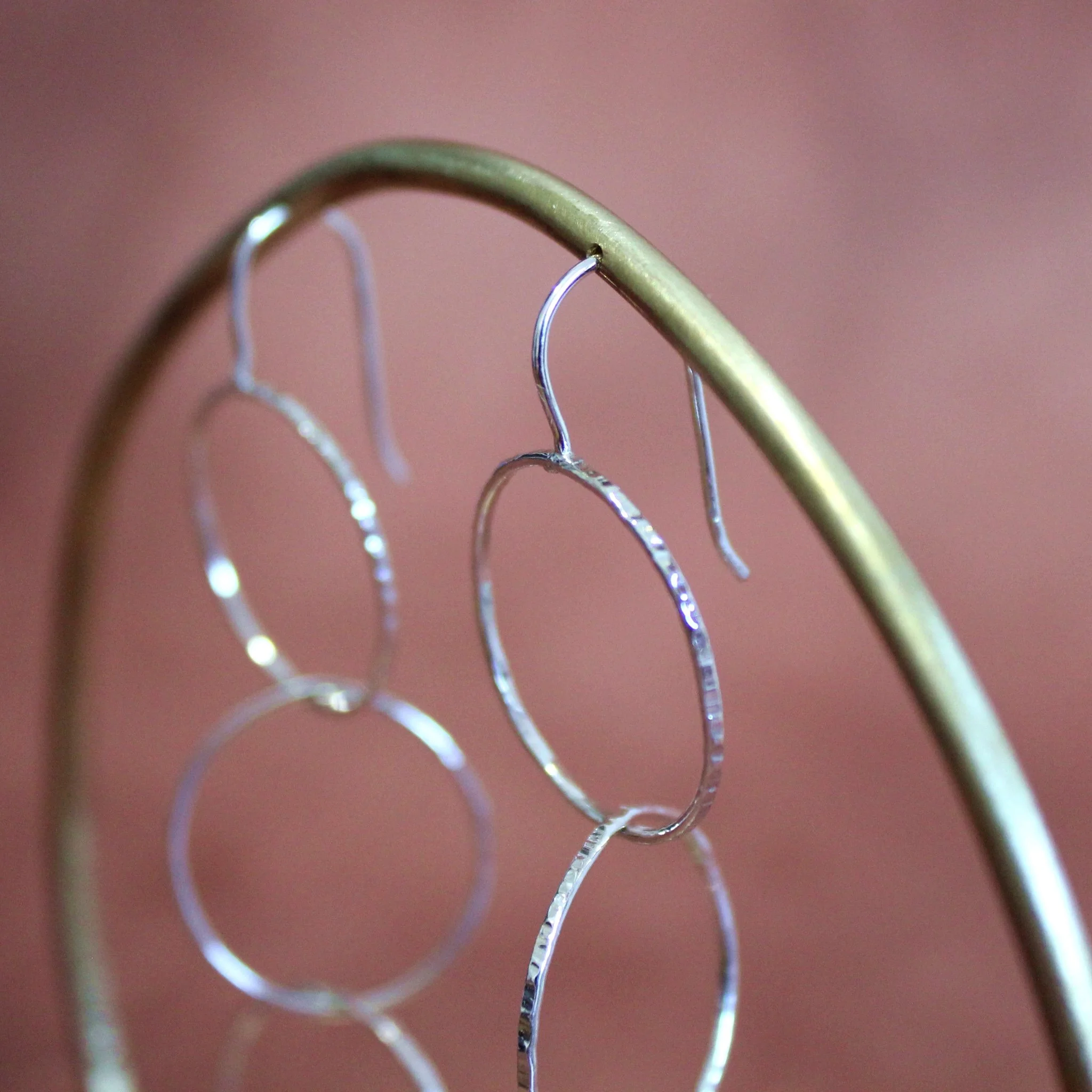 textured-silver-circle-drop-earrings-side-view-on-stand.jpg