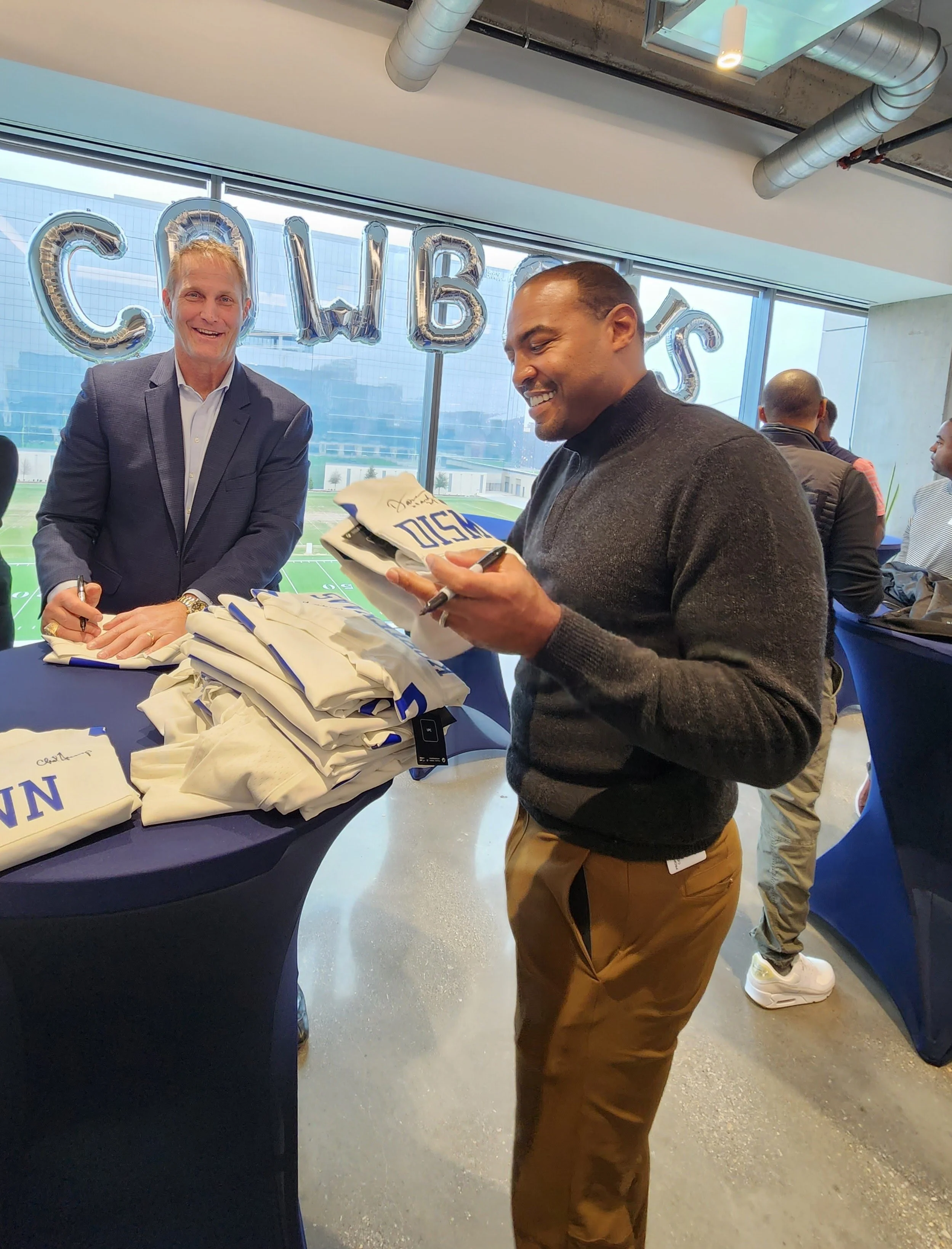 Chad Hennings and Darren Woodson sign jerseys for FirstWave