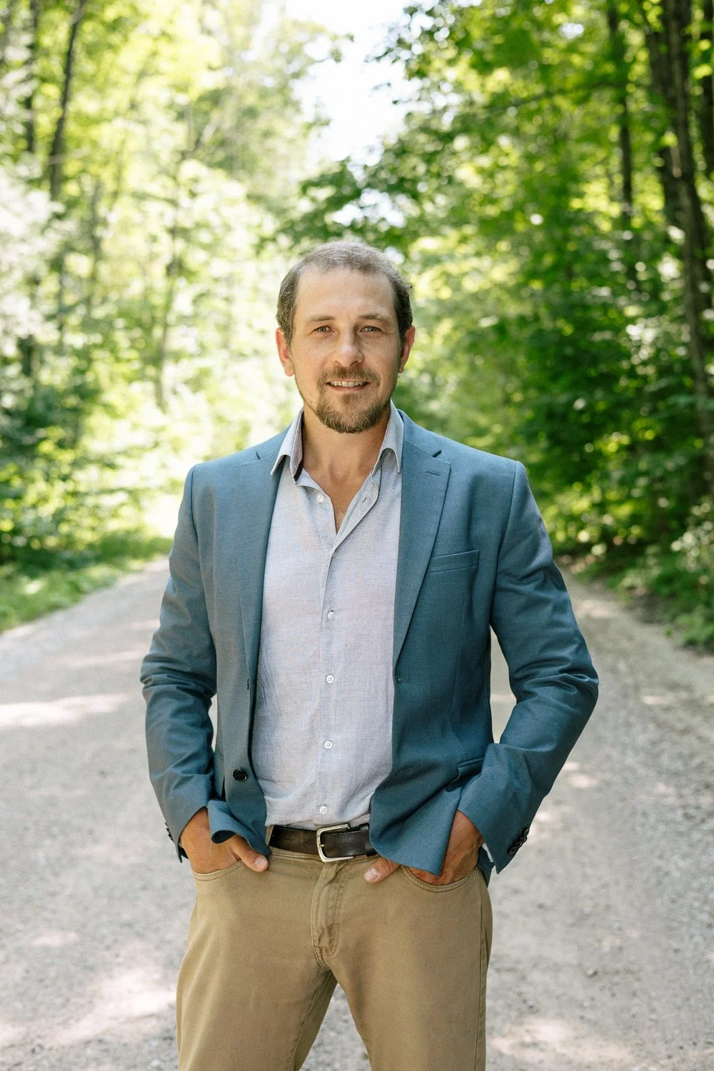 Joel Loughead wearing a light blue blazer standing on one of the rural roads in the Municipality of Grey Highlands