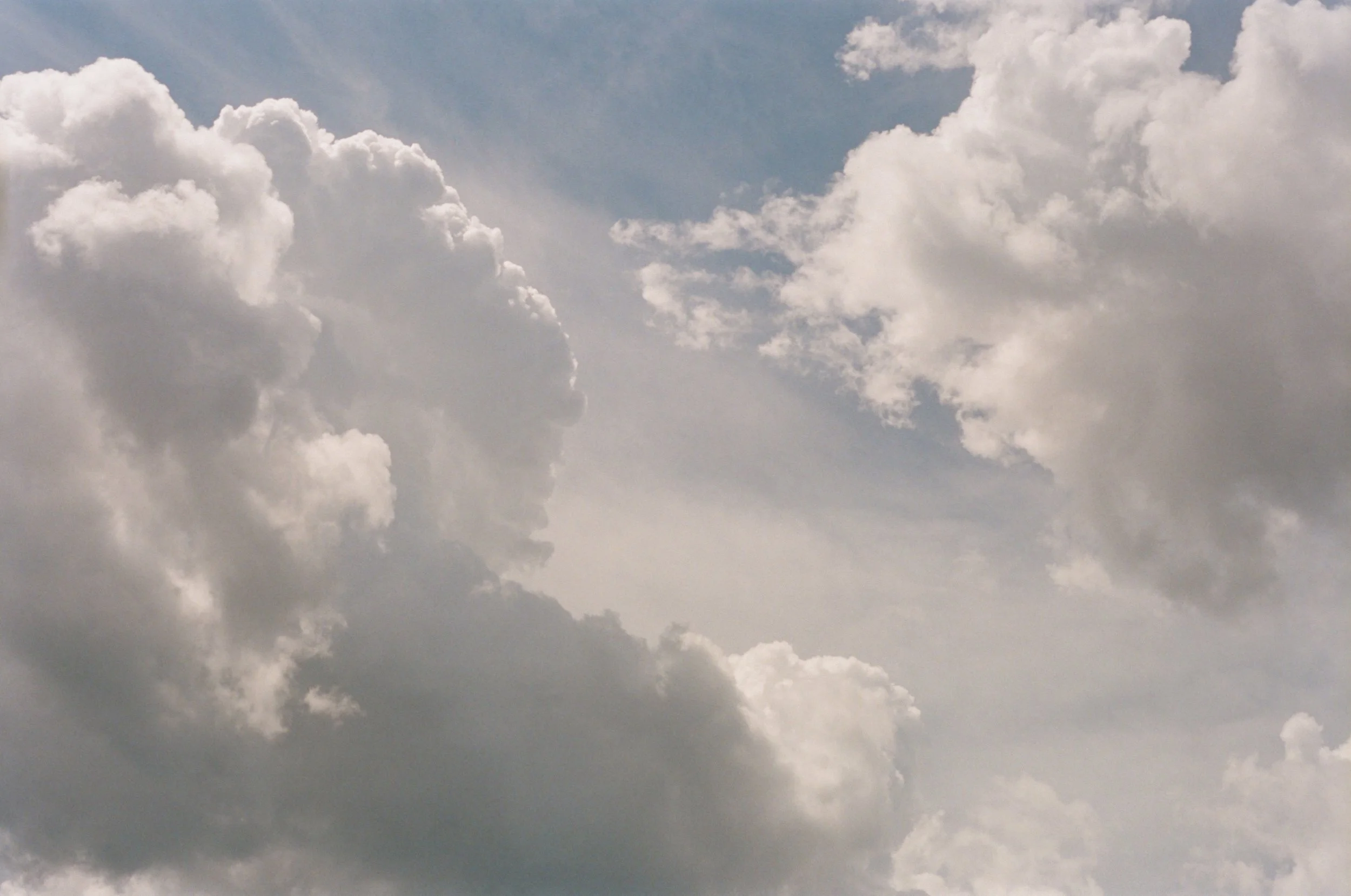 Cloudy sky with large, fluffy white clouds and patches of blue sky in Grey Highlands