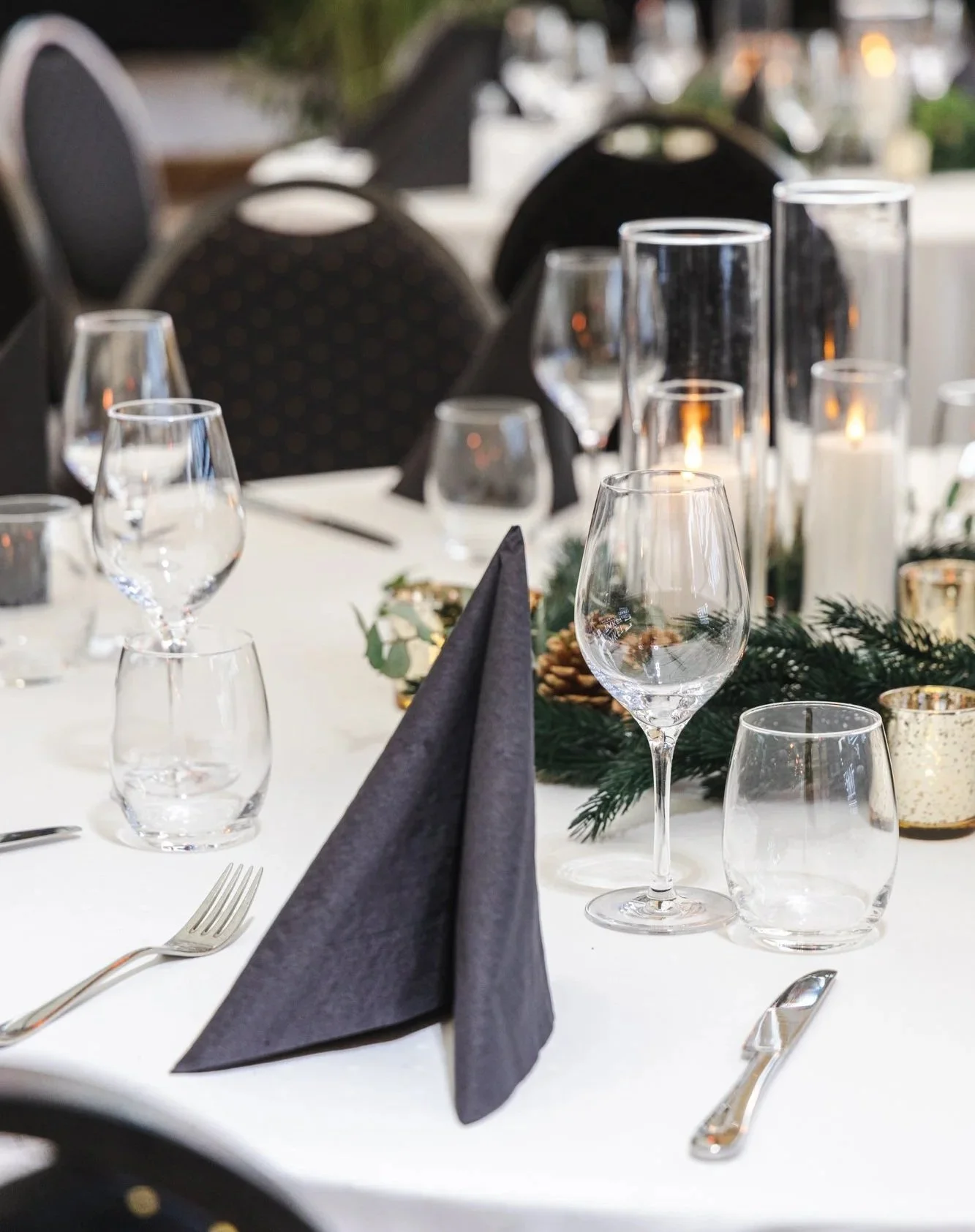 Bilde av dekket bord med glass, julepynt og hvit duk på takterrassen, hovedlokalet på TAKET Steen og Strøm Oslo