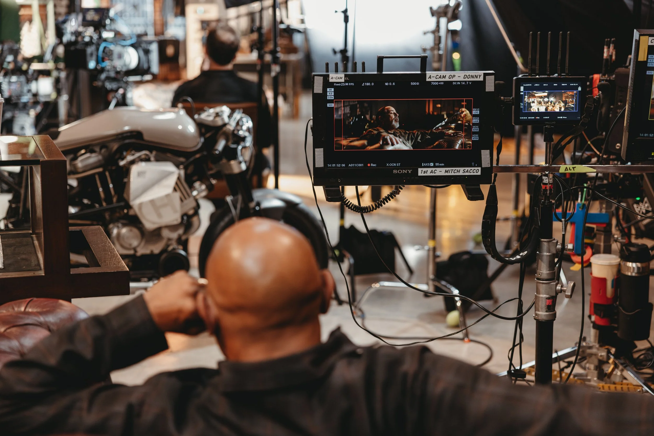 Analysis of filming at an event at Bike Shed Moto LA. Man wearing headphones and watching a screen while sat down