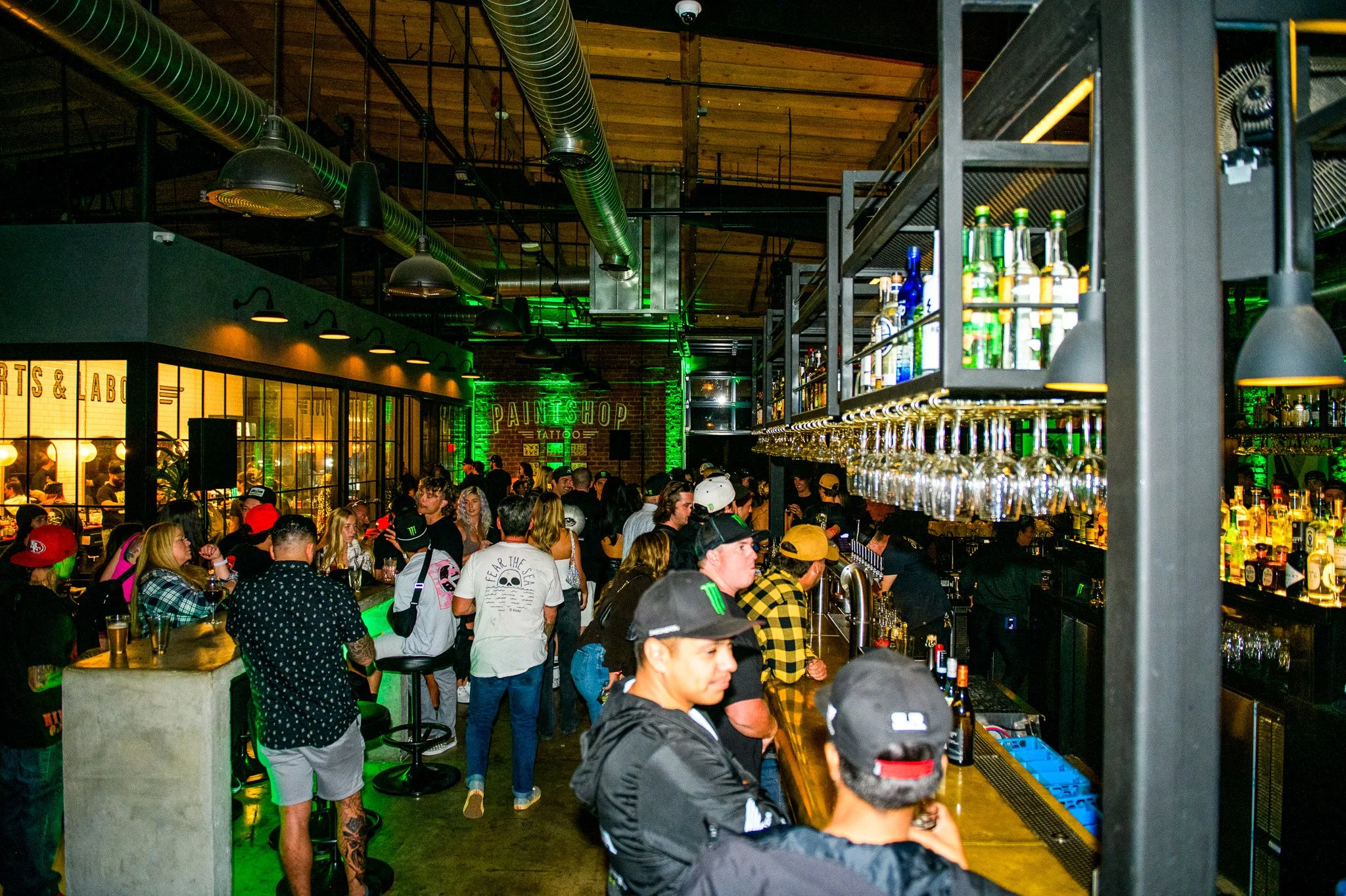 Night time indoor party scene of many event guests drinks and chatting