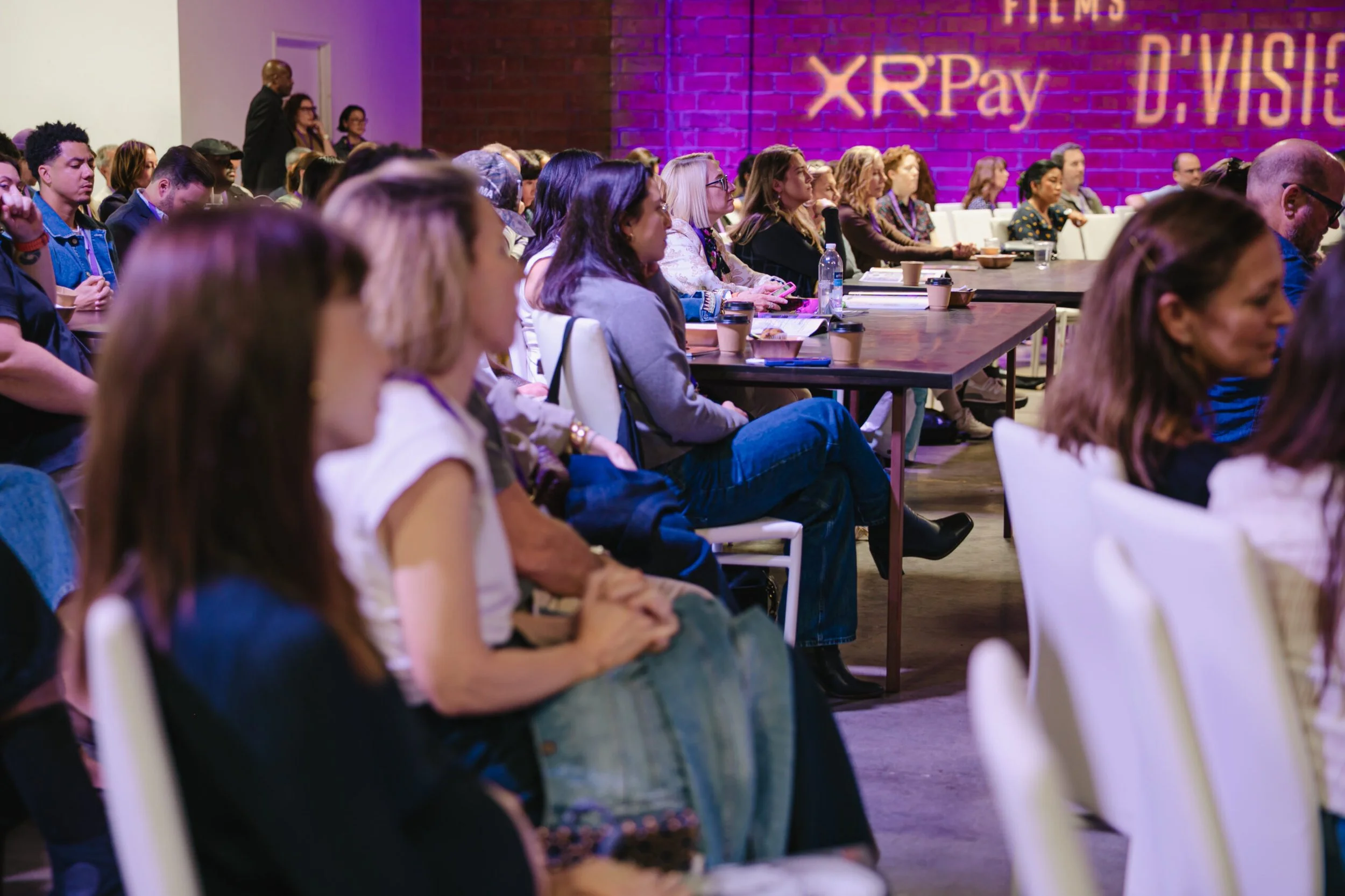 Side of shot of guests listening to panel talk at a sit down event