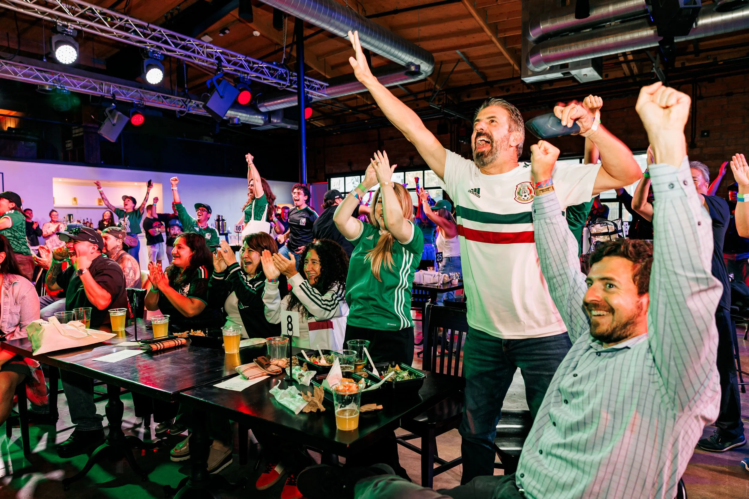 Soccer fans celebrating in a dynamic scene of a watch party event