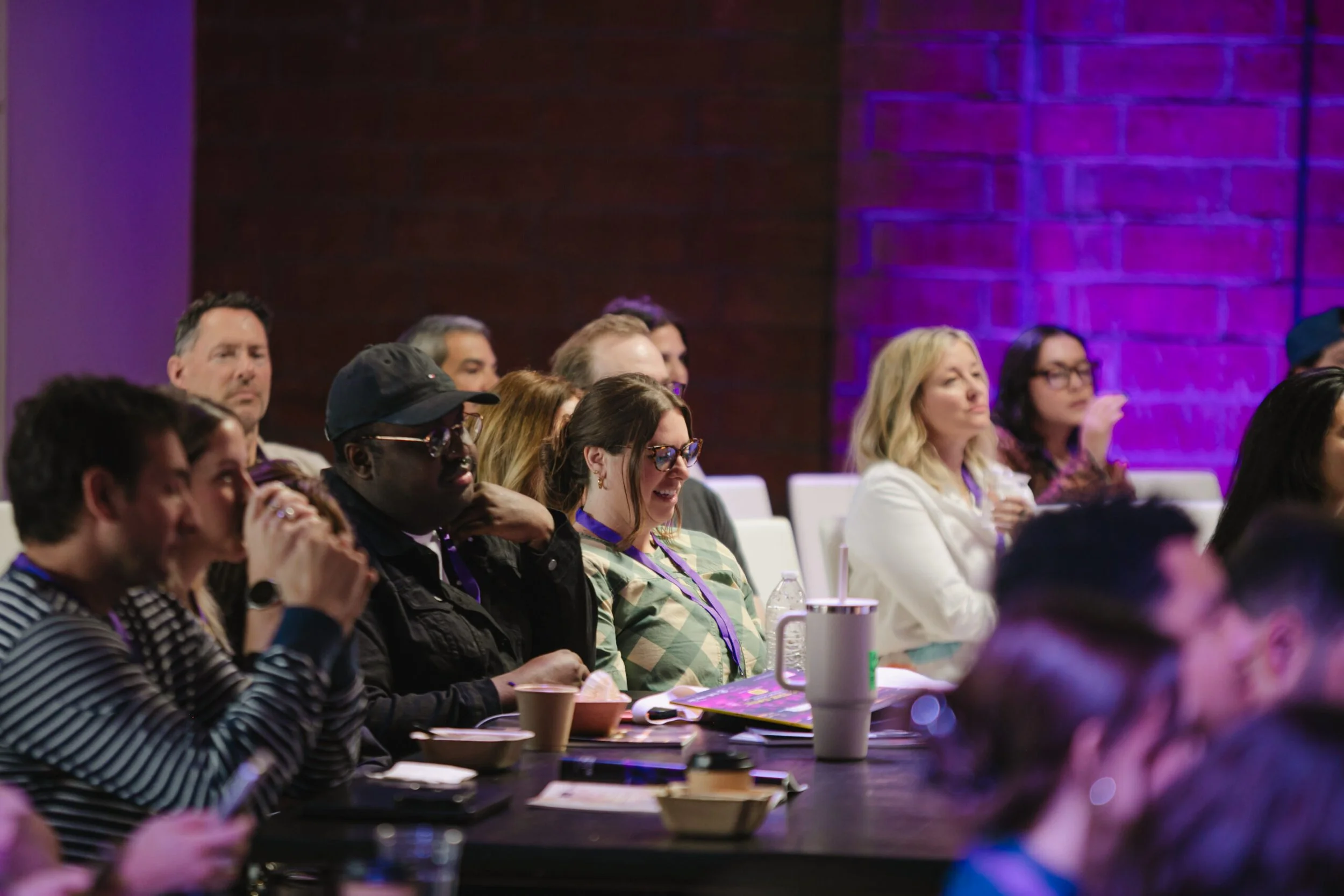 Close up shot of guests at an event centred around panel talks with purple moody lighting
