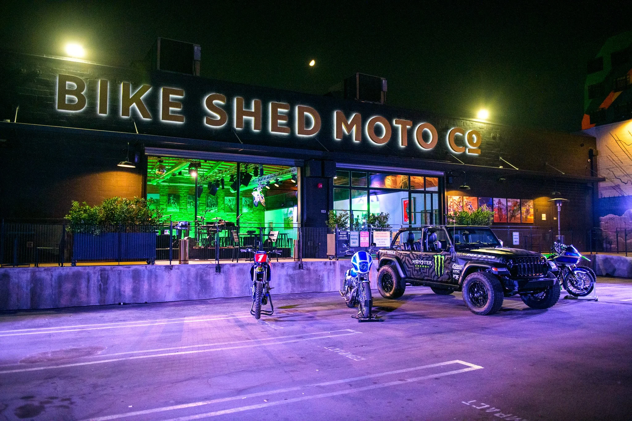 Purple lights illuminating the front of the Bike Shed venue during an event at Bike Shed Moto LA