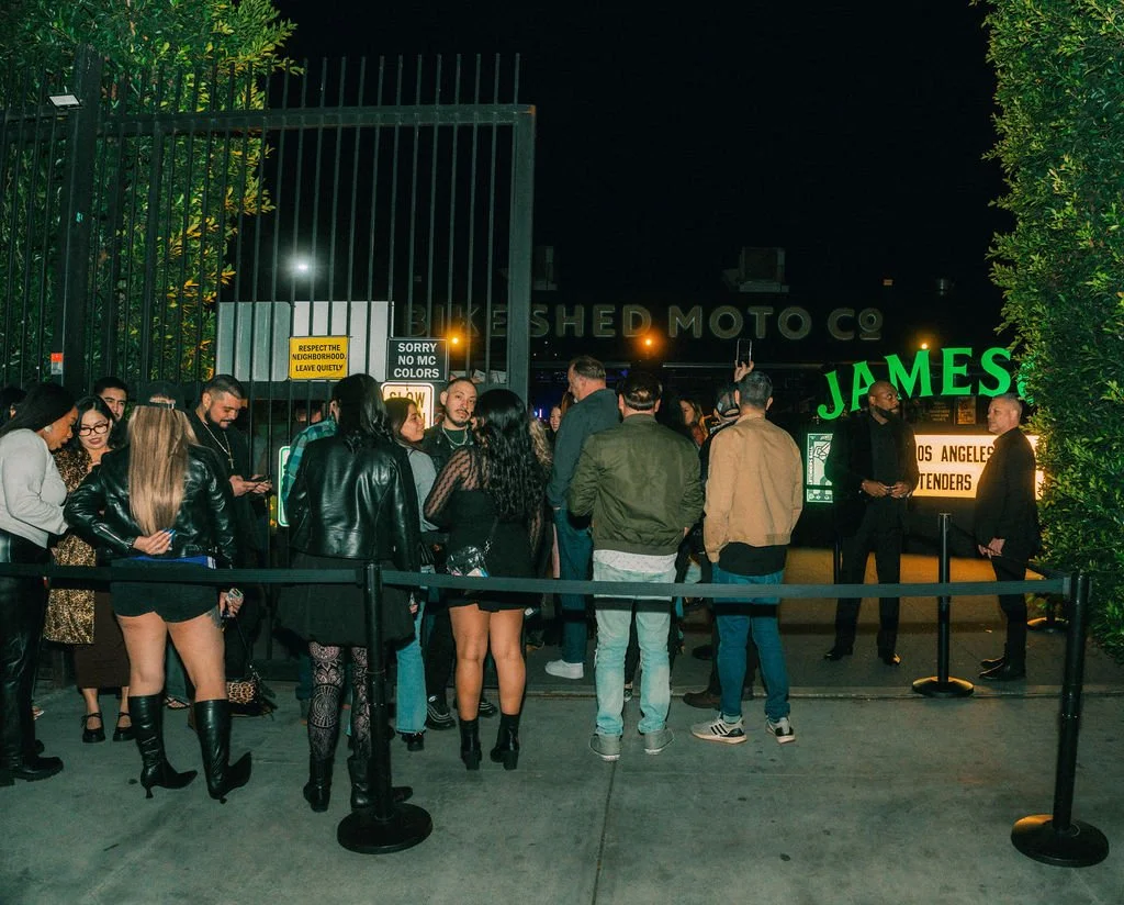 Outdoor queue for a Jameson event at Bike Shed Moto LA. Green signs and foliage in the background