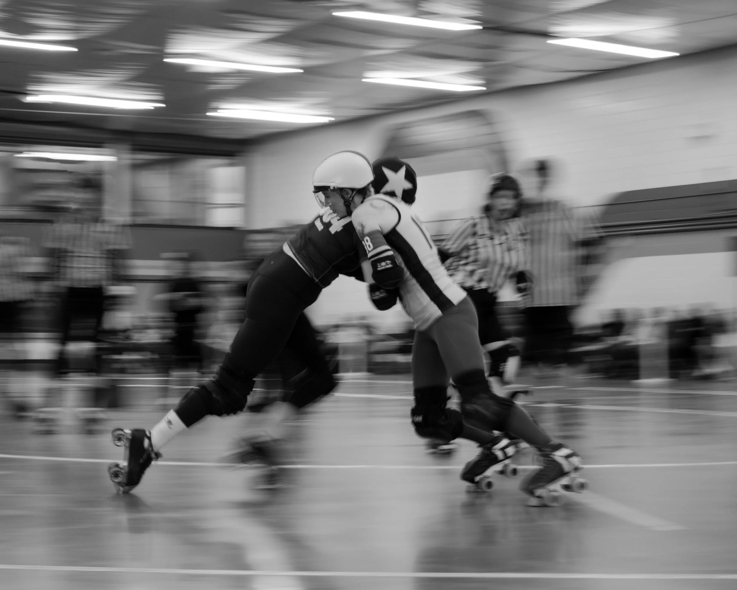 Black and white action photo of two skaters interlocked on their toes battling for position during a fast-paced match in Victoria, BC.