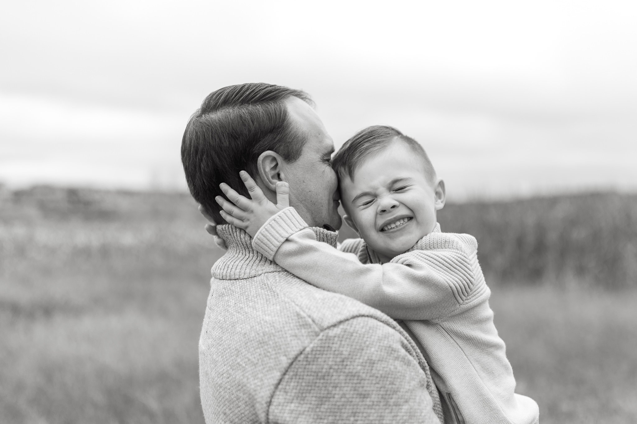 Candid black and white photo of father and son during family session in Calgary, Alberta
