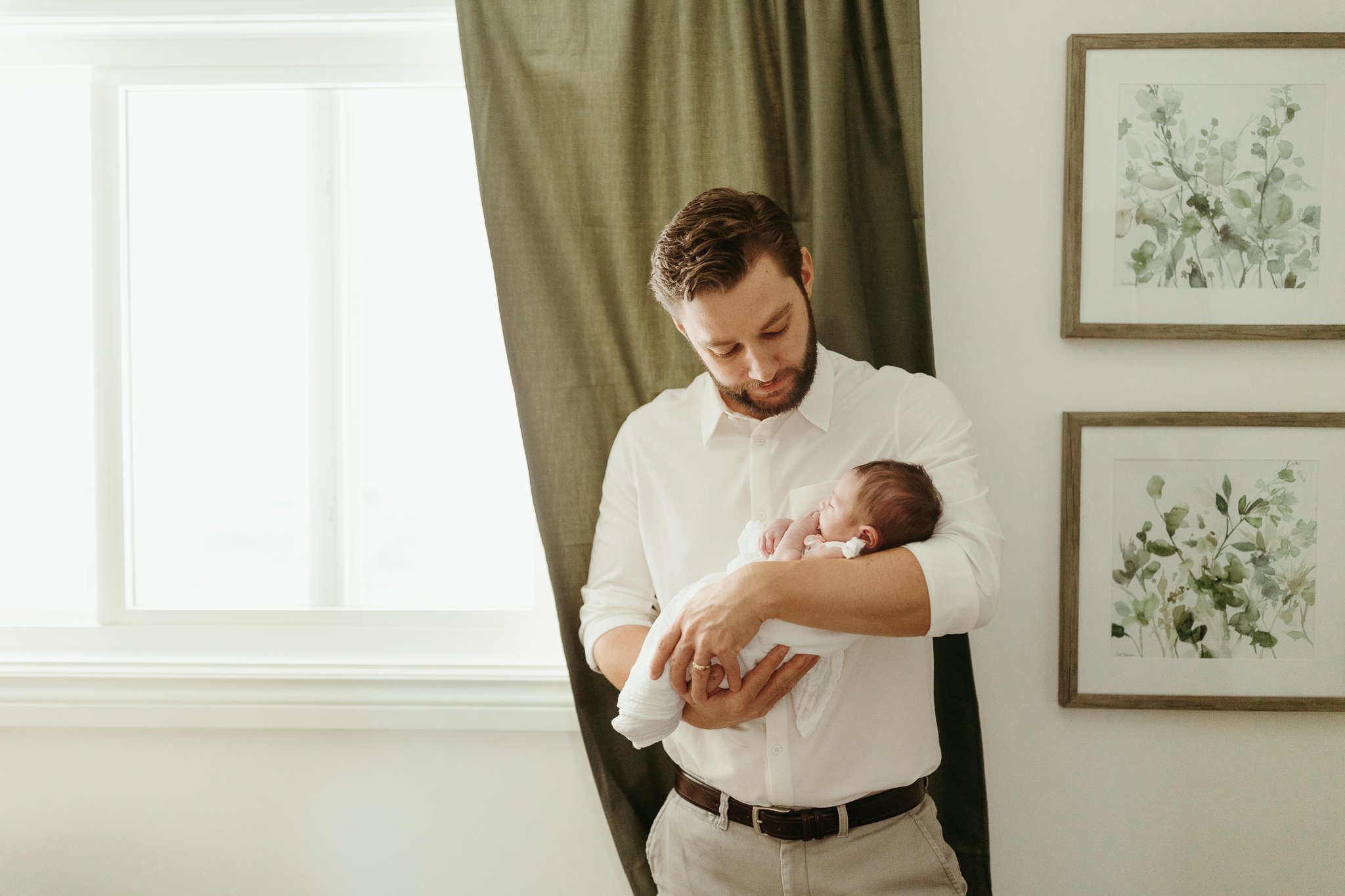 Dad holds his baby daughter in his home in Calgary Alberta
