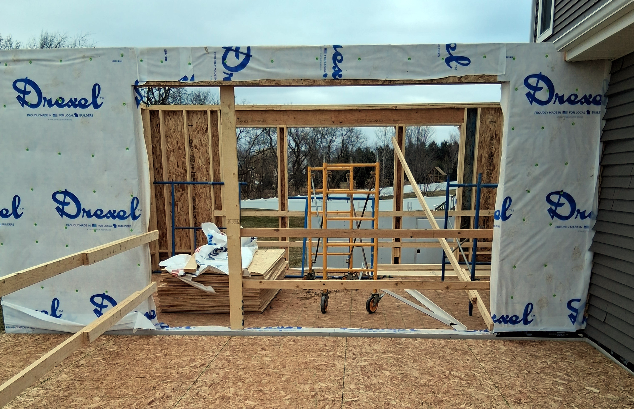Framed home addition under construction, showing new walls and windows as part of a major home renovation. 
