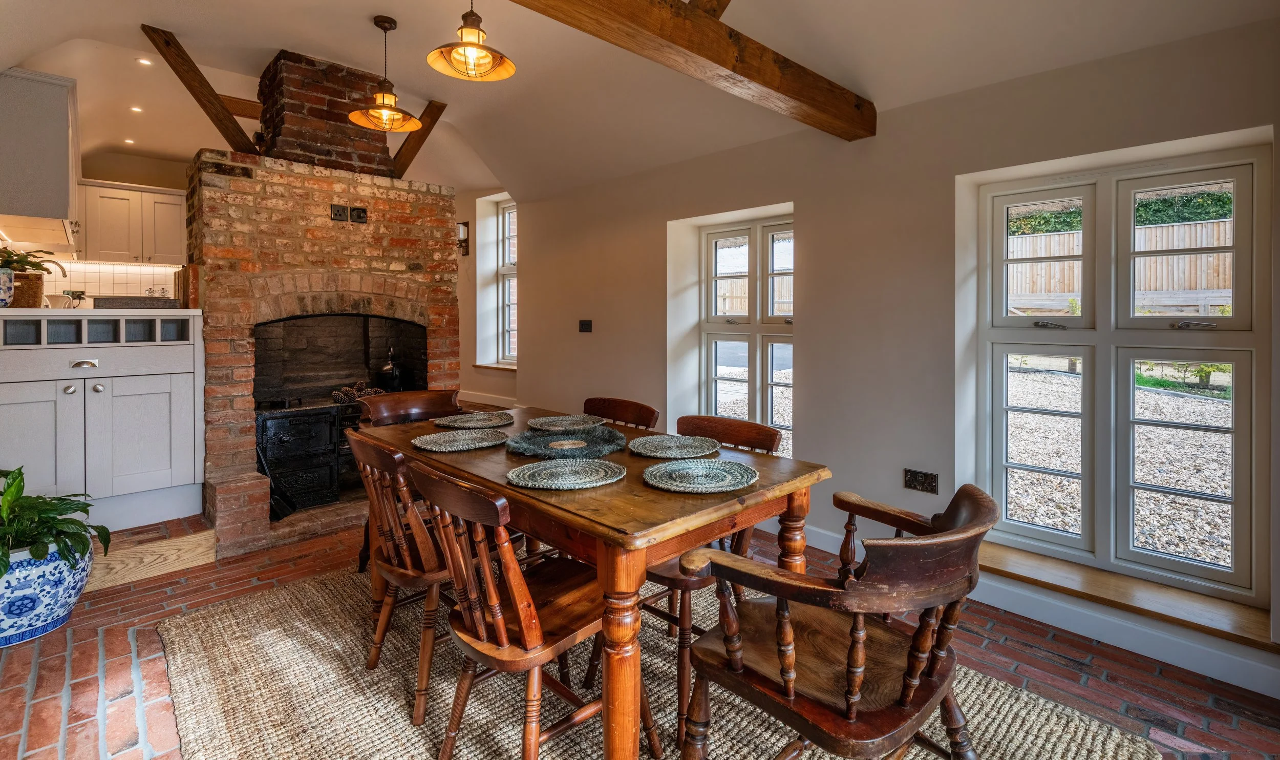A beautiful laid out dining area with a fireplace and large windows.
