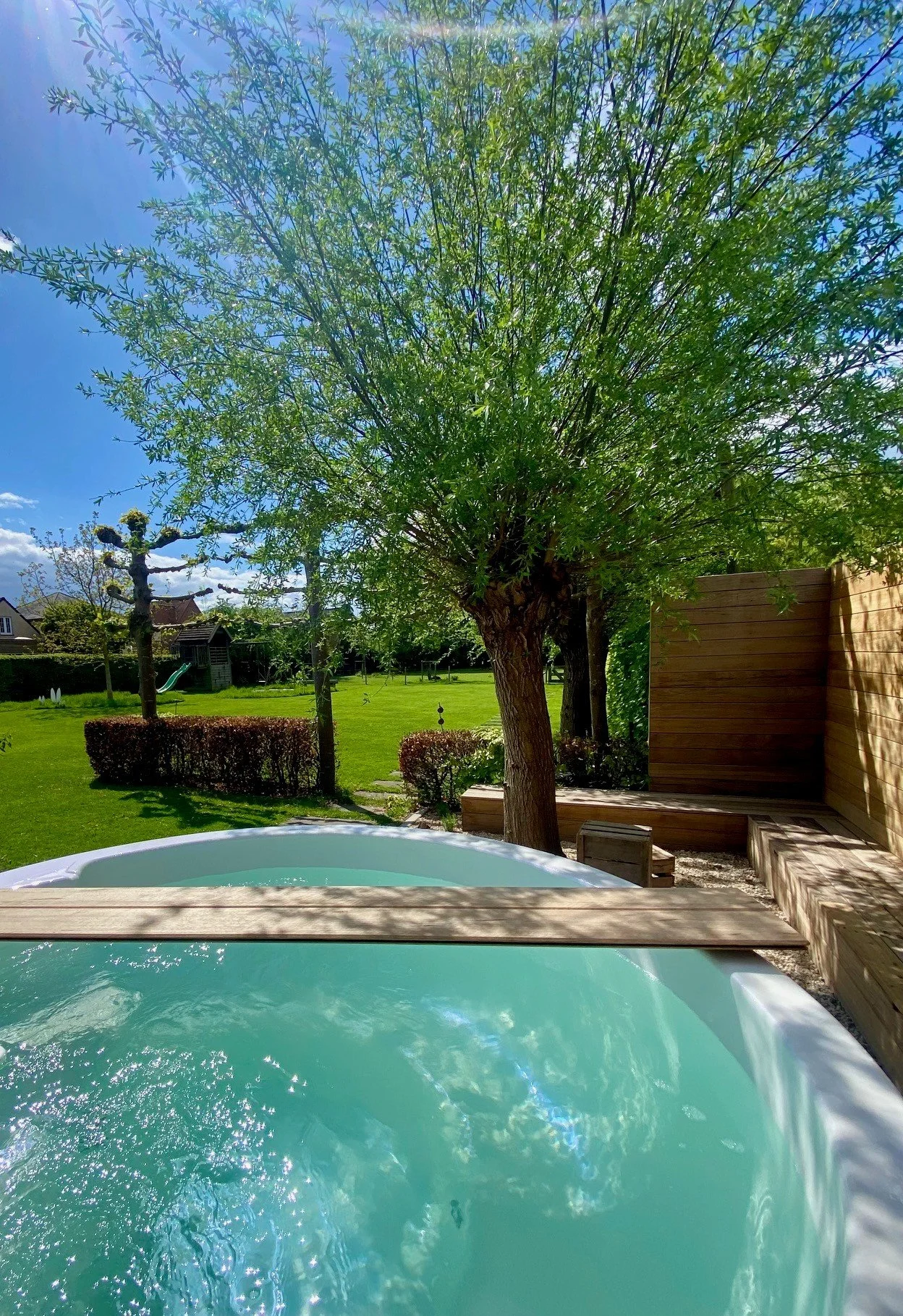 Hottub in de zomer gebouwd door Wellnez Atelier, onder een blauwe lucht