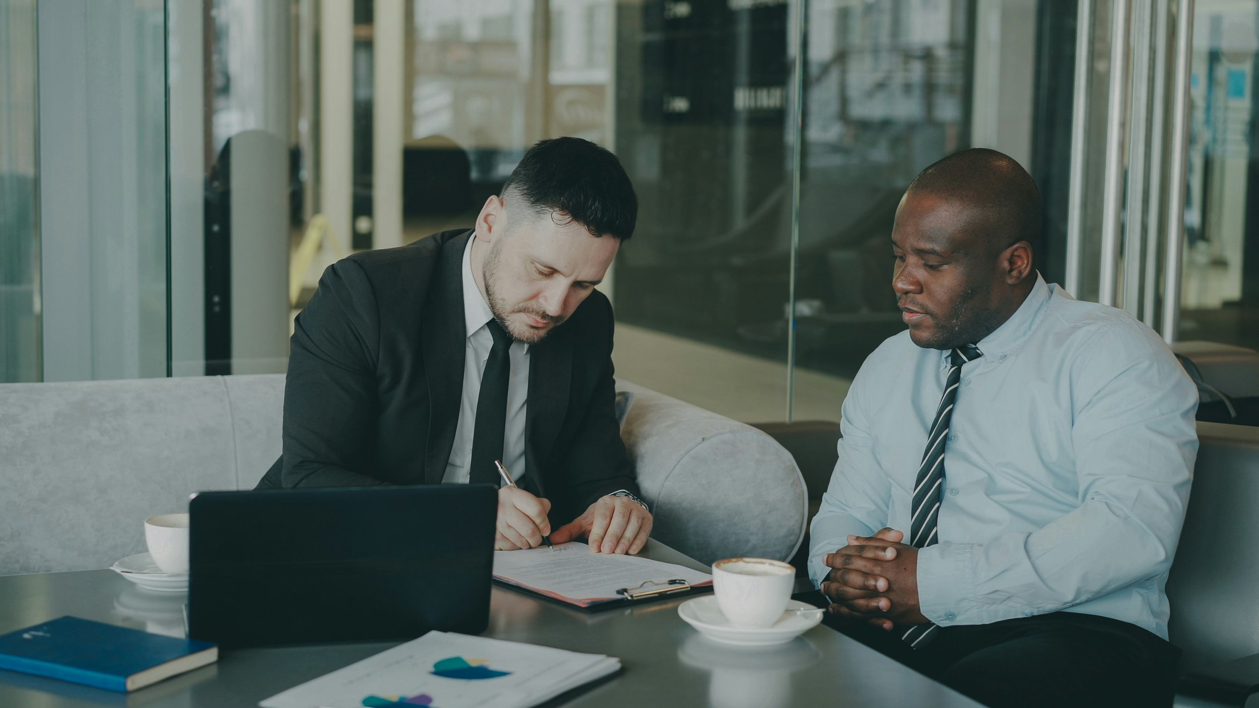 two men sit, conversing in a job interview.