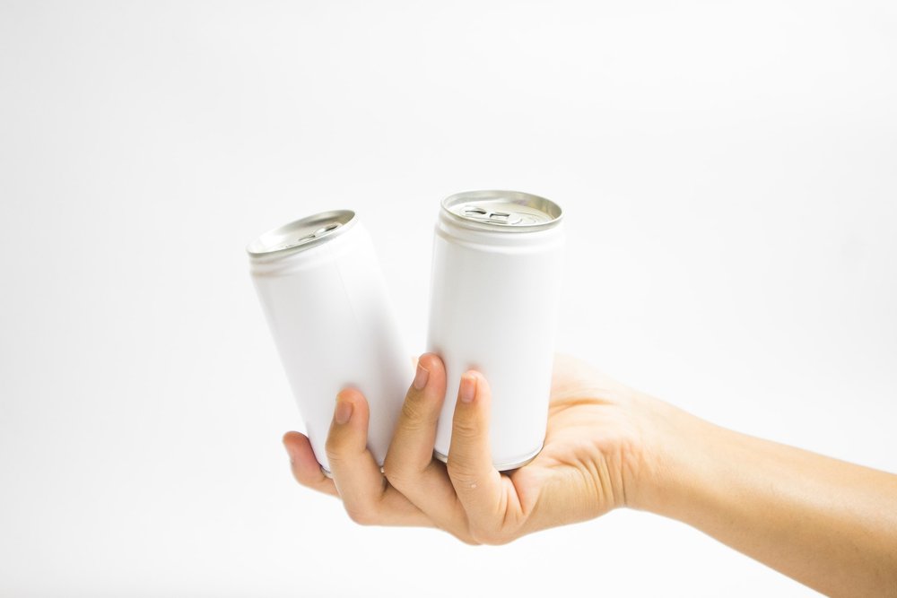 Image of two cans in a persons hand