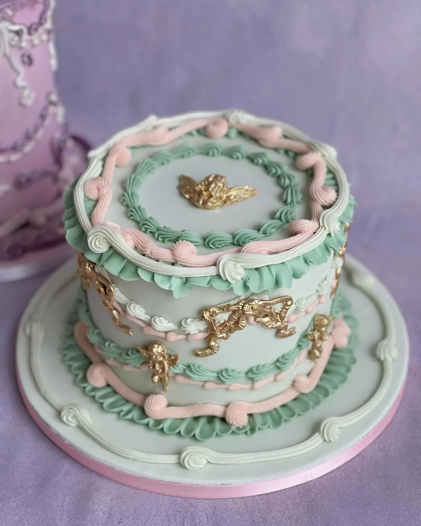 A cute little vintage pair of cakes 💜🤍🩷
Love the mix of ganache piping, with ornate sugar pieces and pearls. And the colour combinations are 🙌

.
#cake #cakeart #pipedcake #lambethcake #retrocake #vintagecake #buttercreamcake #luxury #luxurycake 
