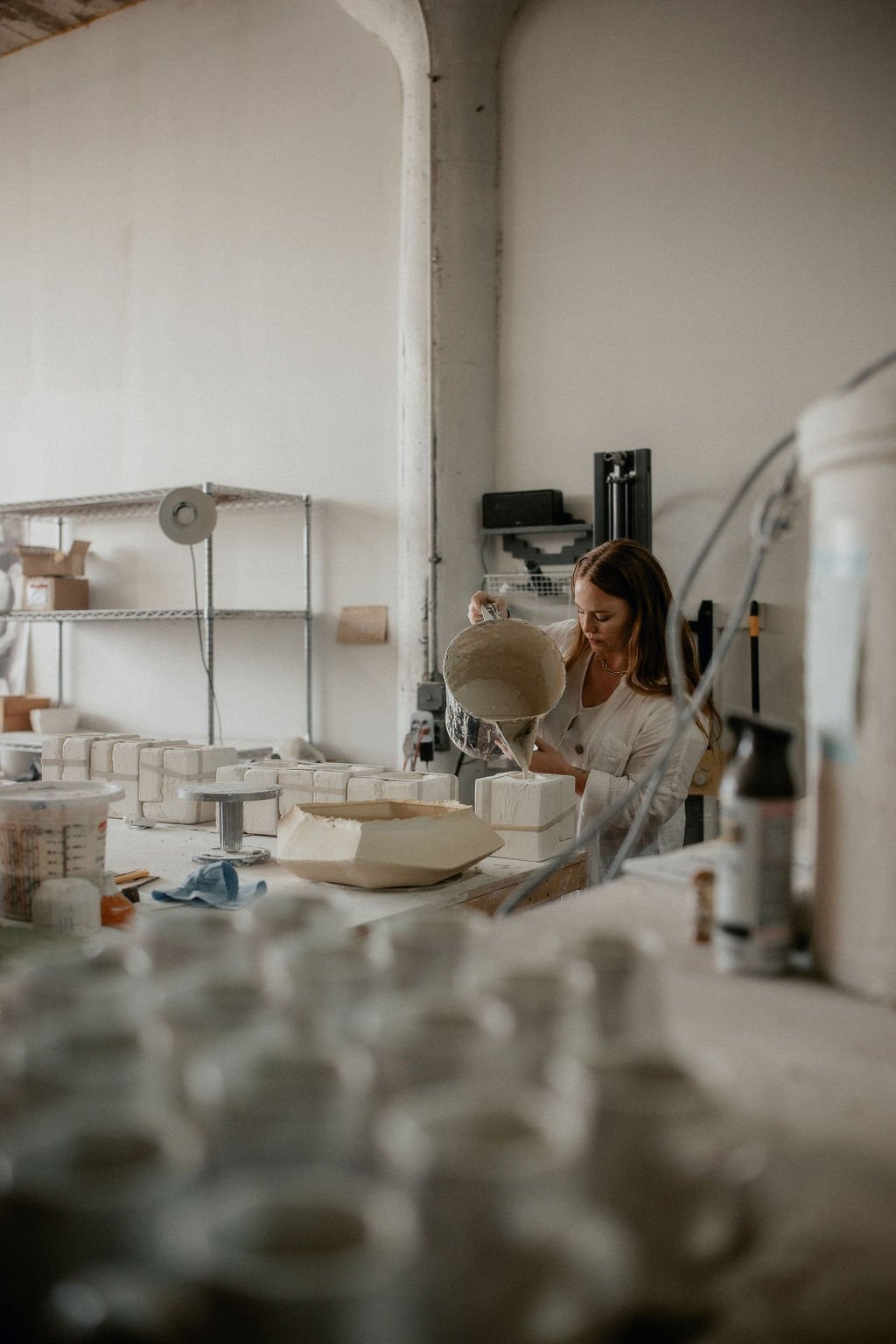  An image of Lauren HB Studio production artist pouring ceramics into a mold 