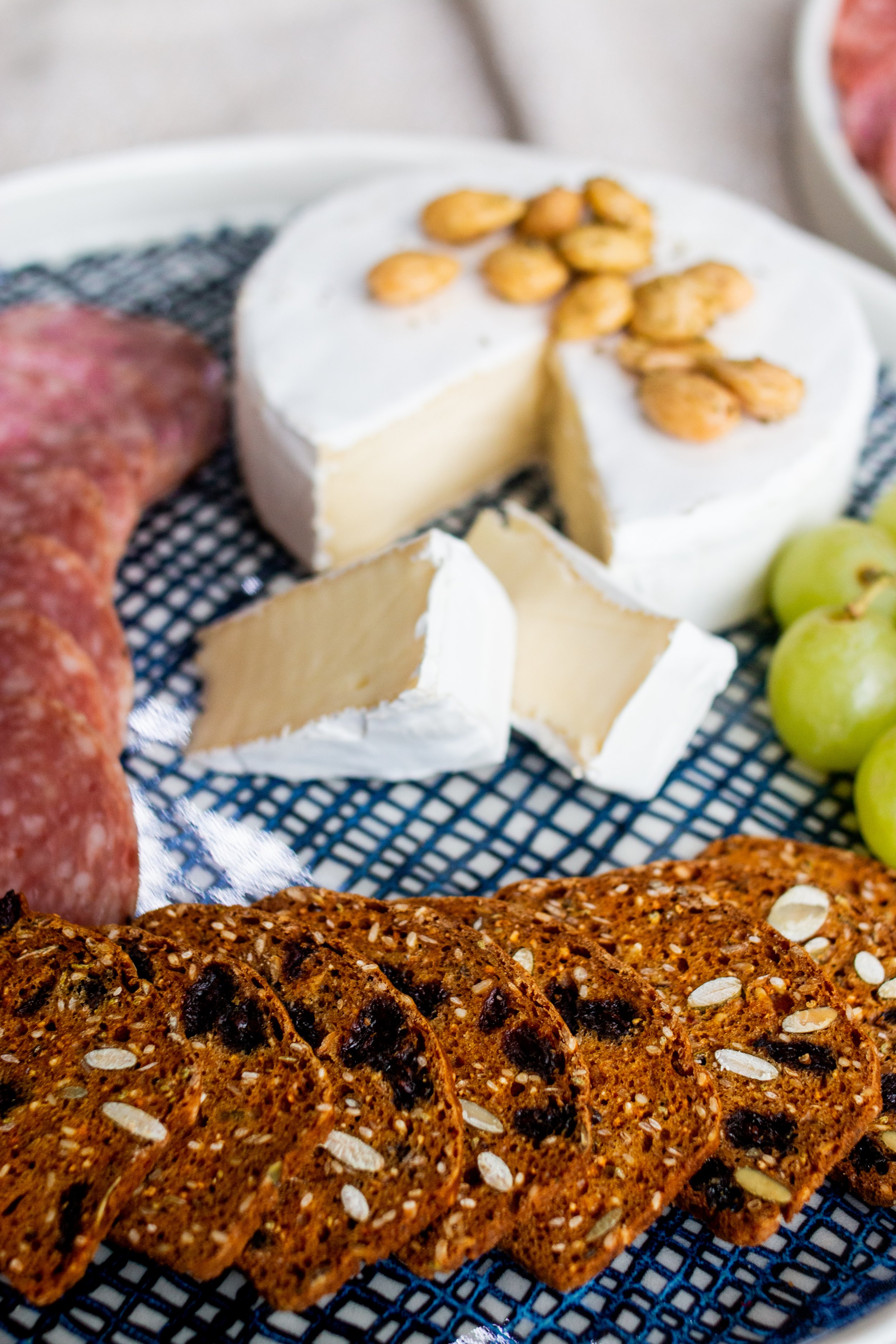  A closeup image of cheese, meat and bread on a handmade plate created by Lauren HB Studio 