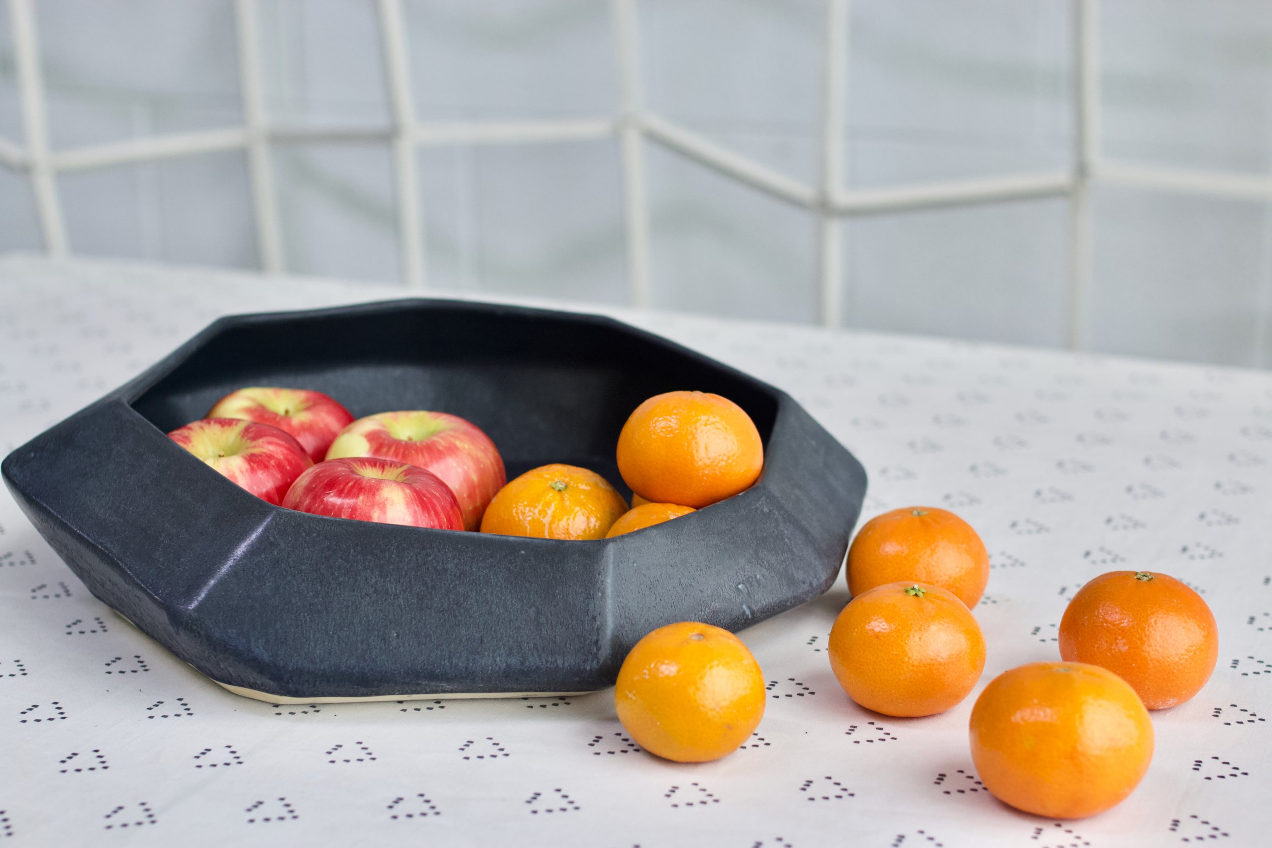  Abstract black ceramic plate a part of the Core Collection created by Lauren HB Studio with apples and oranges in it 