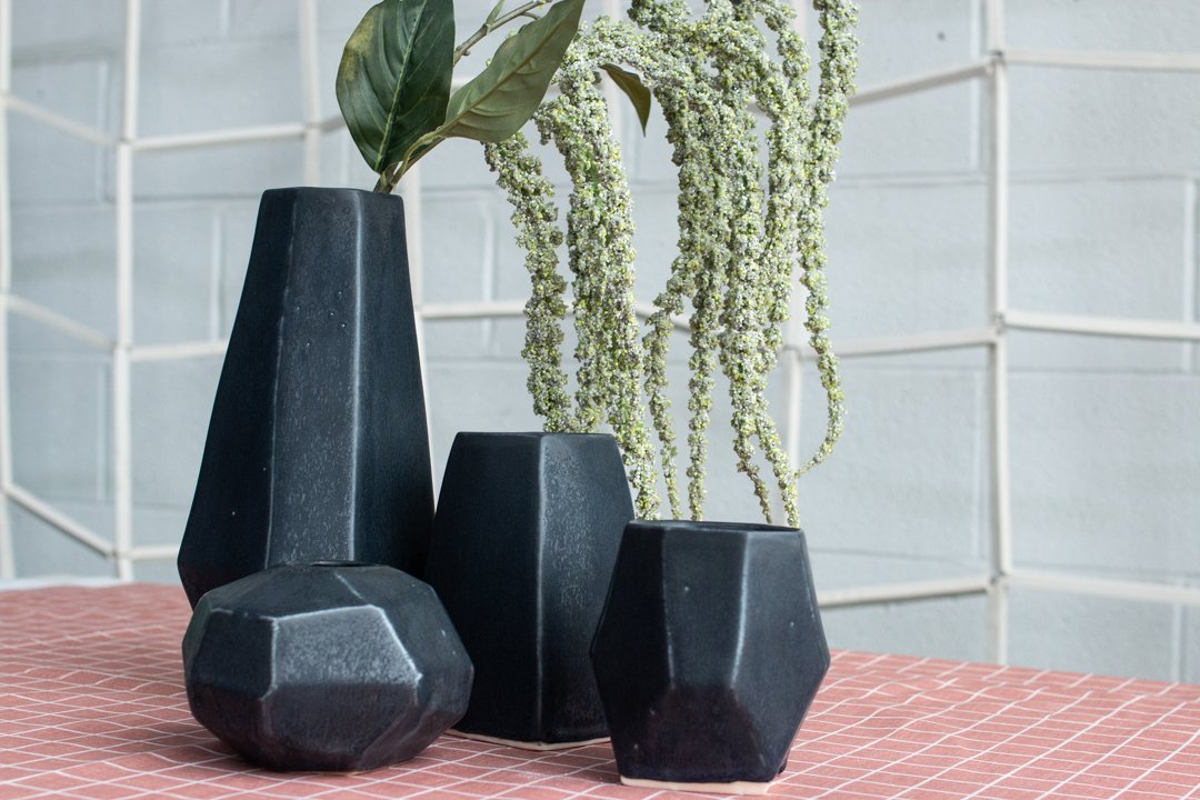  Four black geometric vases of varying sizes in the Juniper collection made by Lauren HB Studio available to shop online 