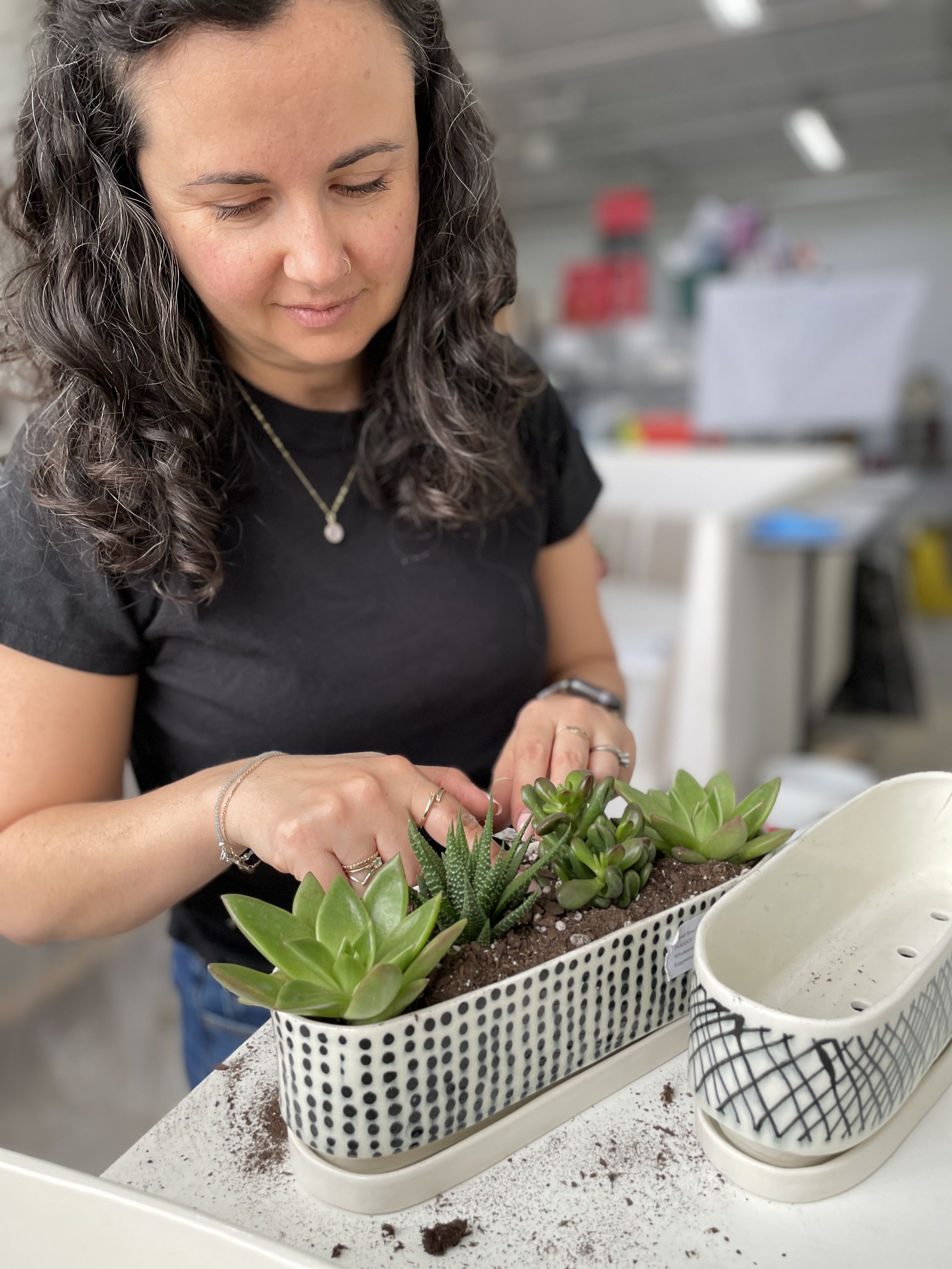  An image of Lauren HB Studio production artist creating succulent planter in long rectangle pot created by Lauren HB Studio available for purchase online 