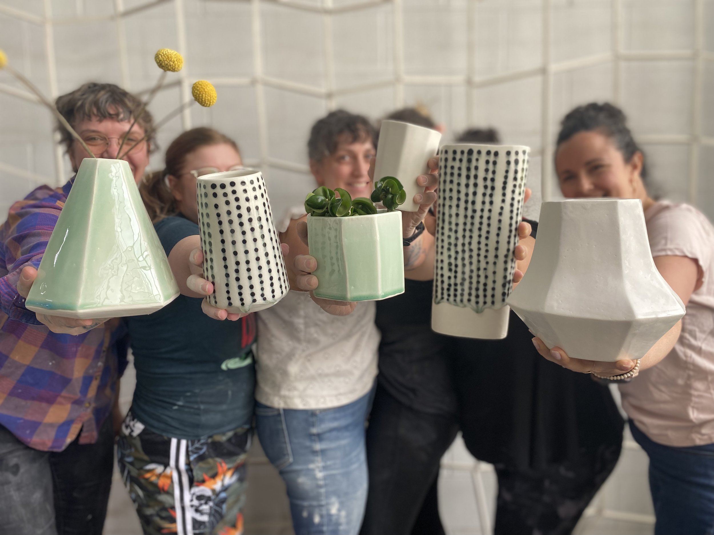  An image of the Lauren HB Studio team holding different vases created by the production artists and available for purchase online and wholesale 