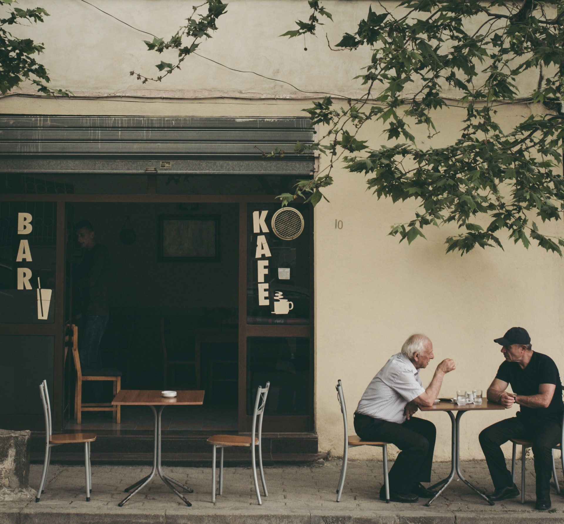 two men talking at an outdoor cafe