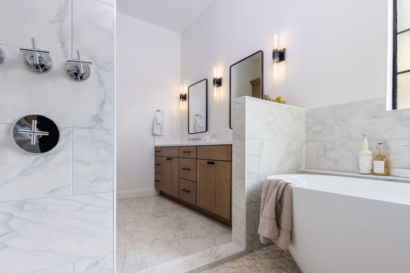 Relaxation is calling your name! Step into this serene sanctuary where every detail whispers calm. From the elegant marble tiles that grace the walls and floor to the minimalist touches around the soaking tub, this bathroom is designed to wash away t