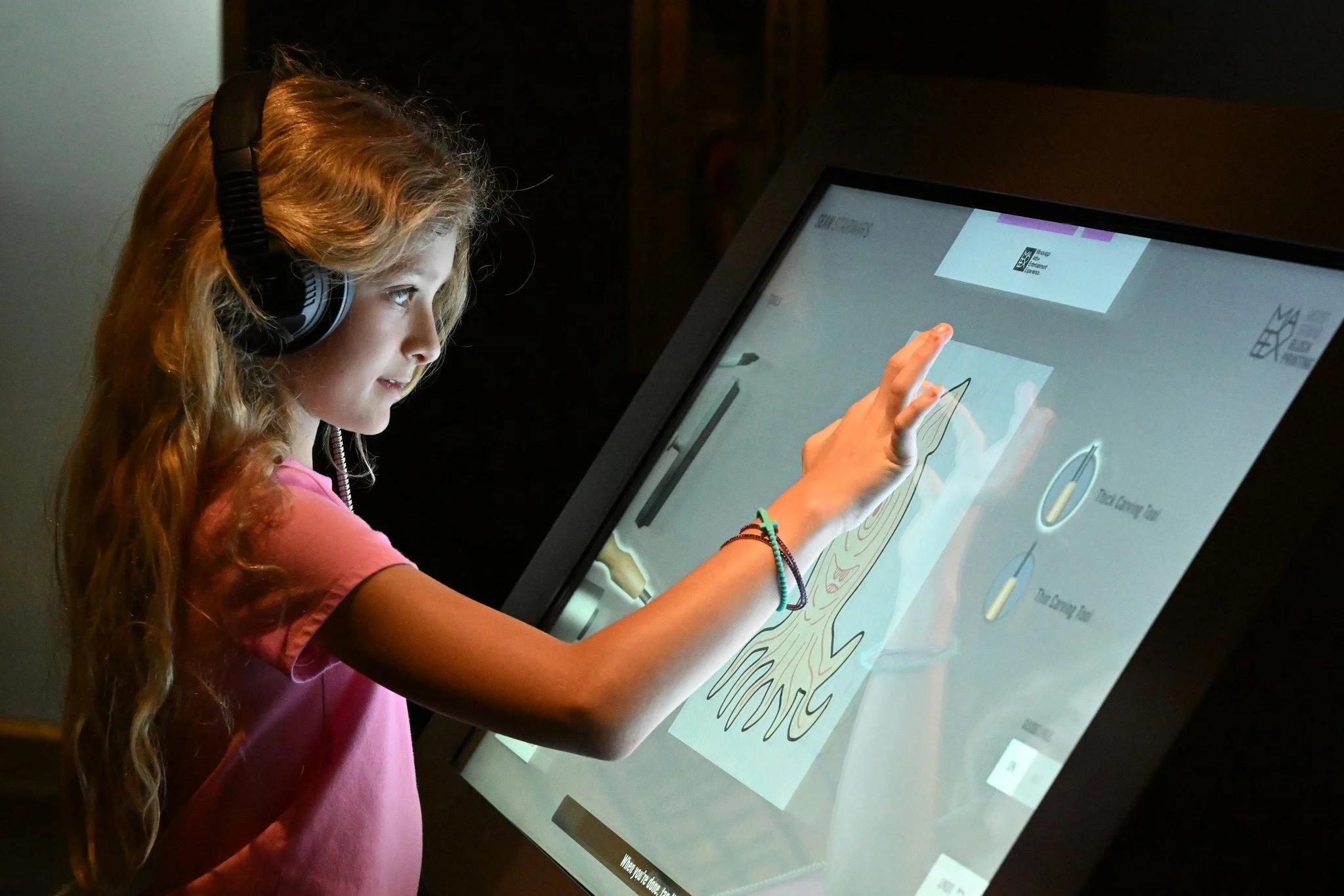child playing with the interactive printmaking exhibit.