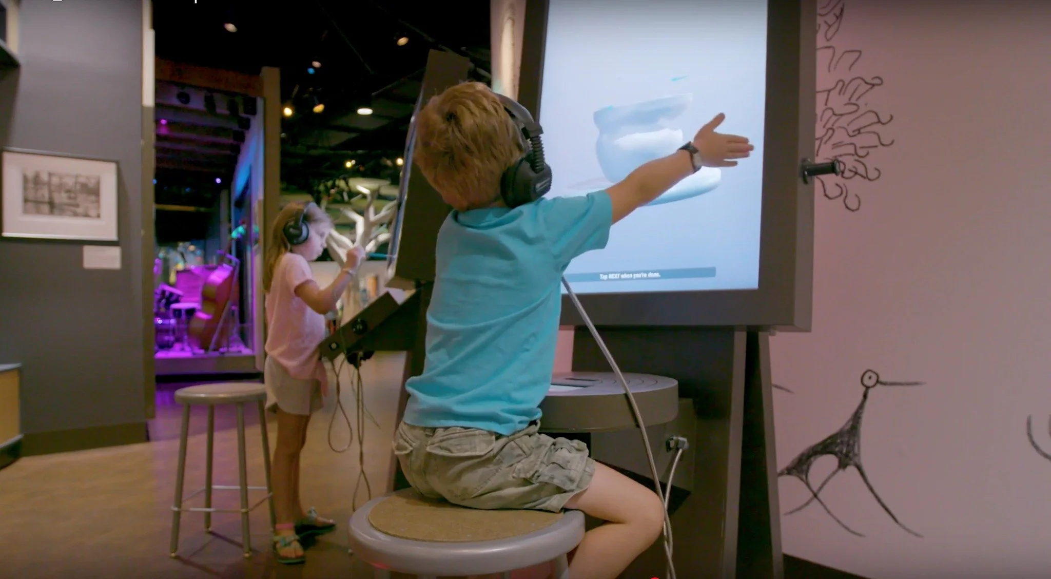 child playing on the interactive pottery exhibit