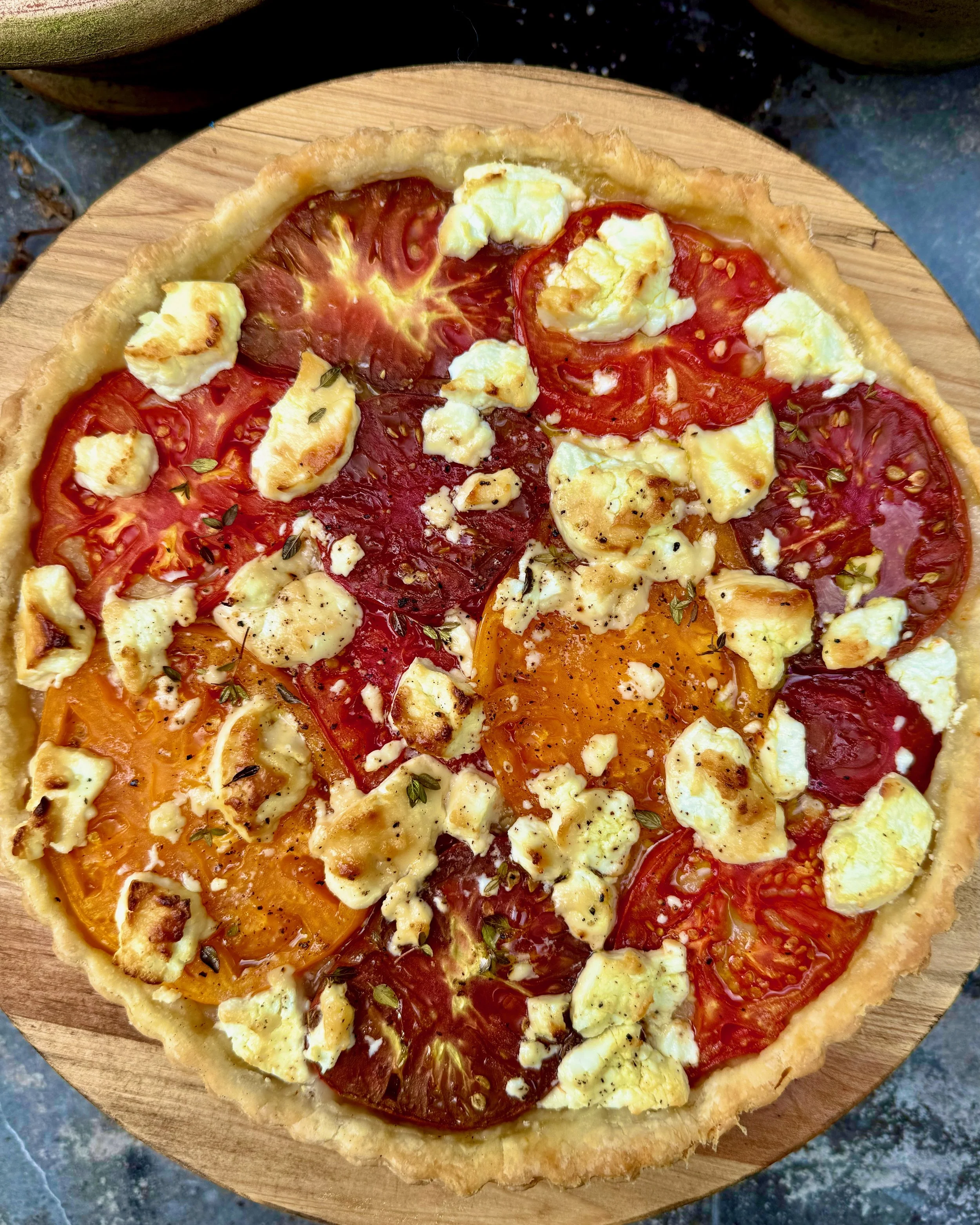 rustic tart with slices of tomatoes and goat cheese