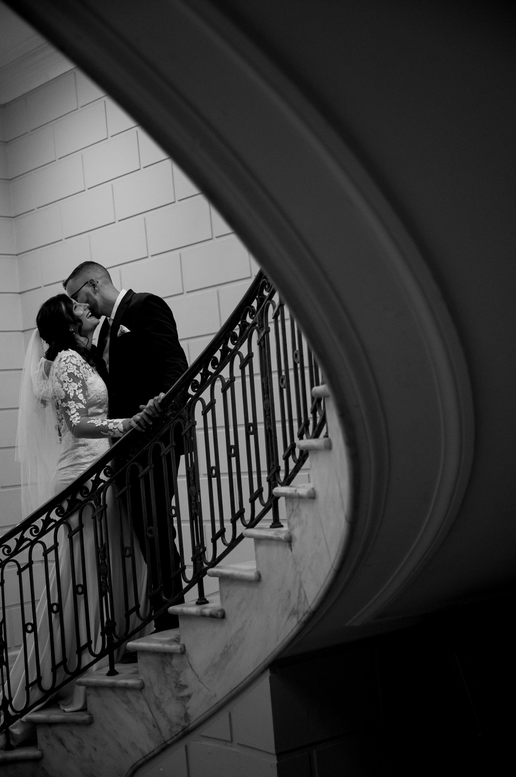 The couple kisses on the stairs
