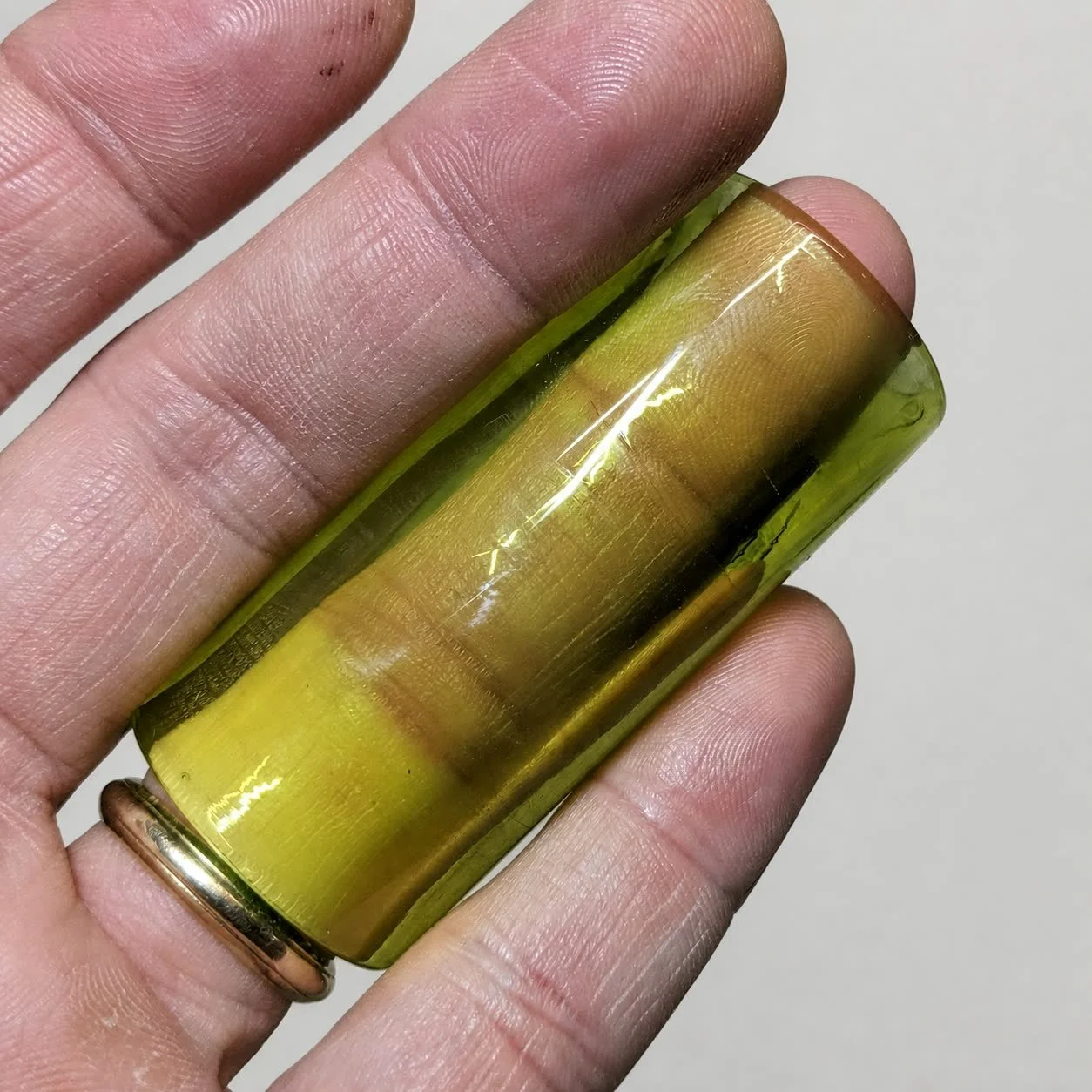 Blacklight Glow #1 non-tapered glass guitar slide shown in its yellow amber natural-light color