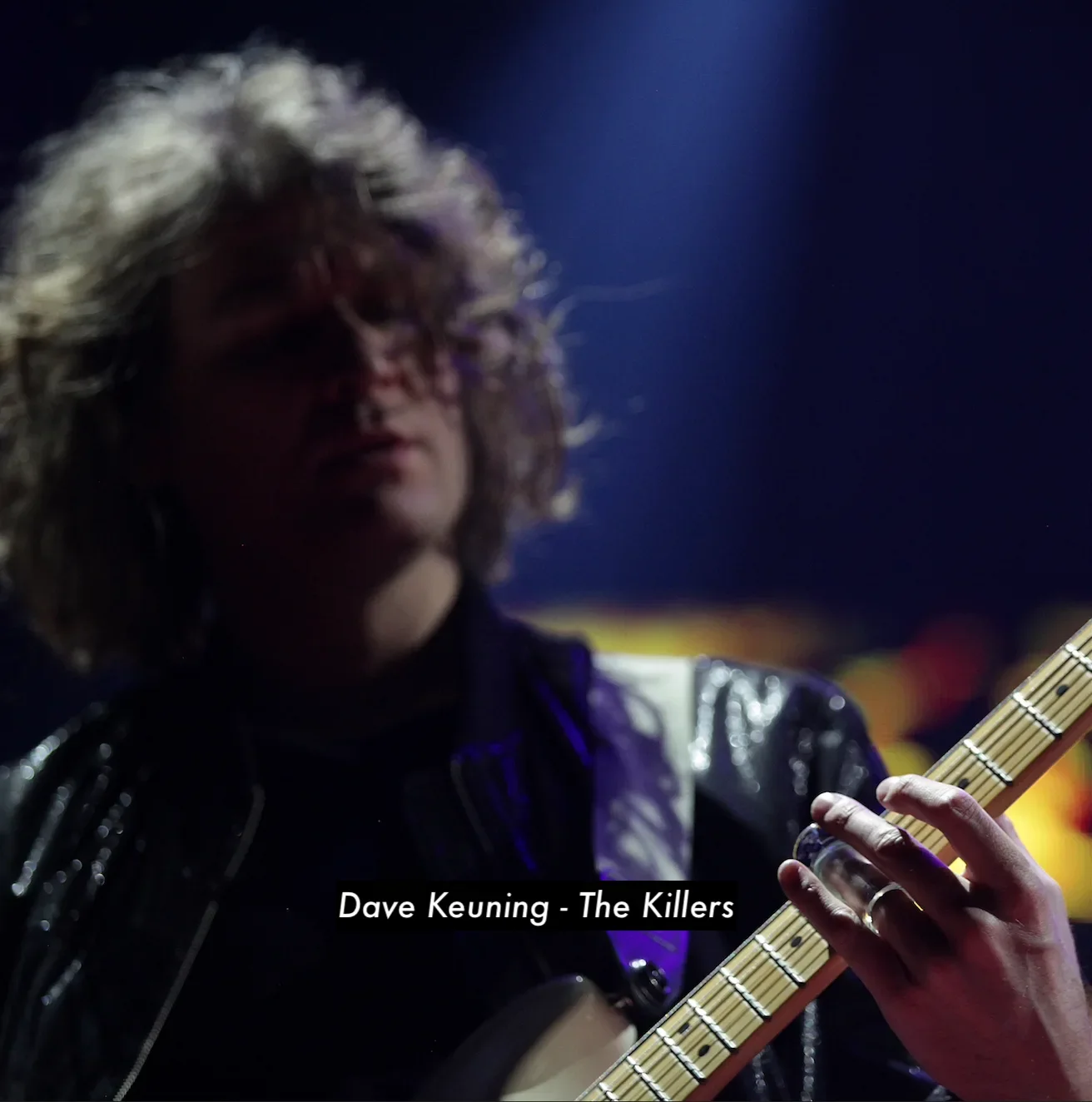 Dave Keuning of The Killers playing guitar on stage with a clear cobalt blue tipped Silica Sound Model 420 glass guitar slide.
