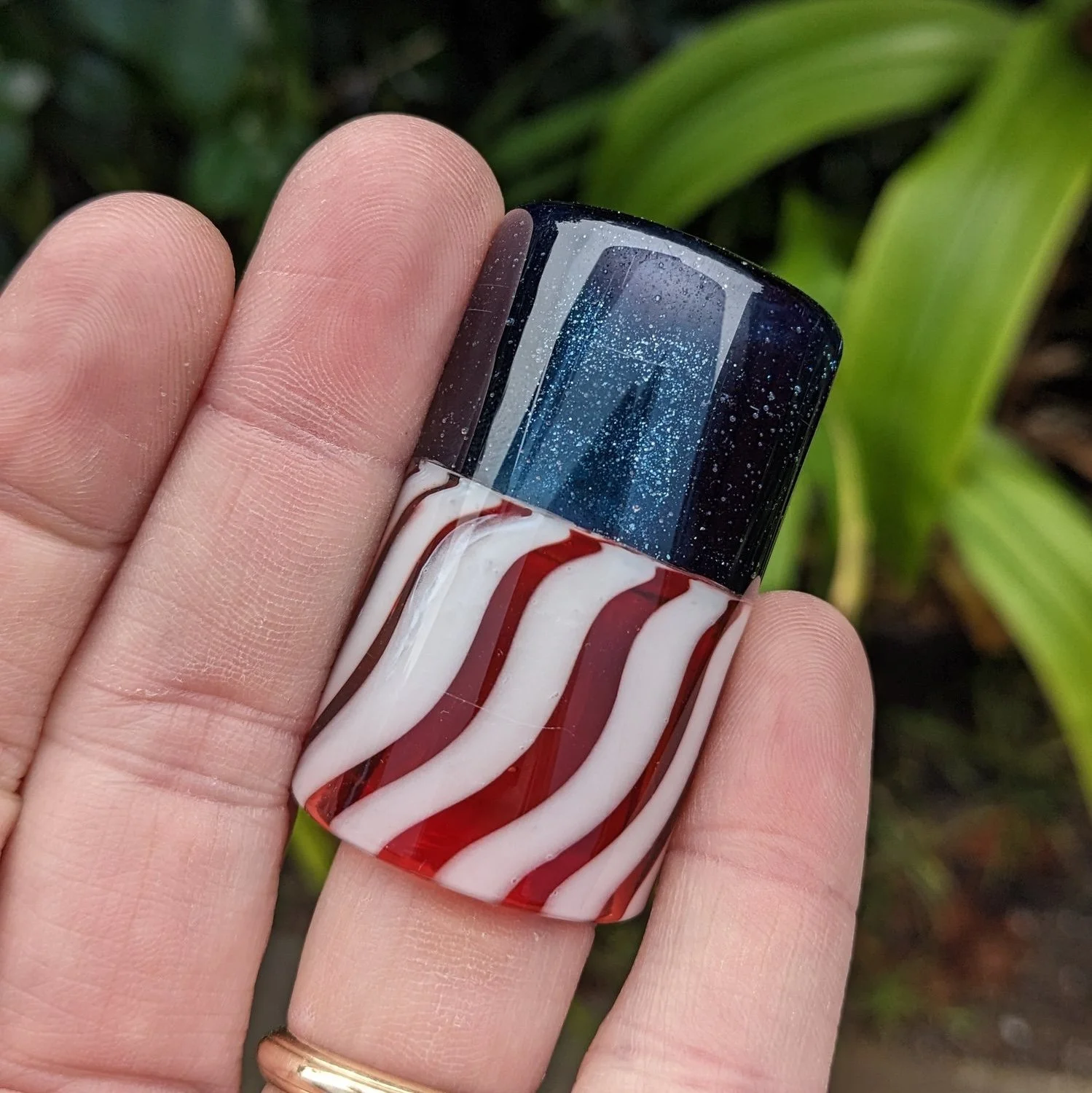 The Liberty Slide #4, handcrafted red white and blue glass guitar slide shown in hand